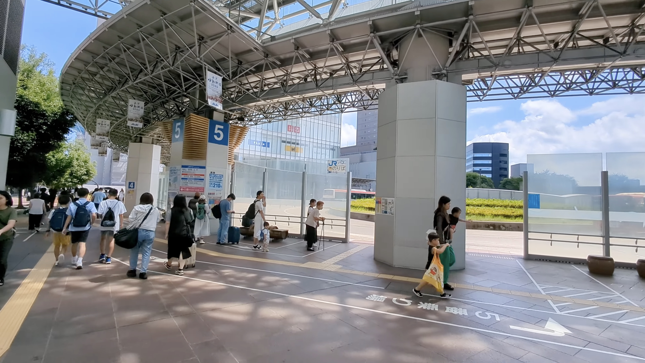もてなしドームの下、バスのりば5番、青空と家族連れ