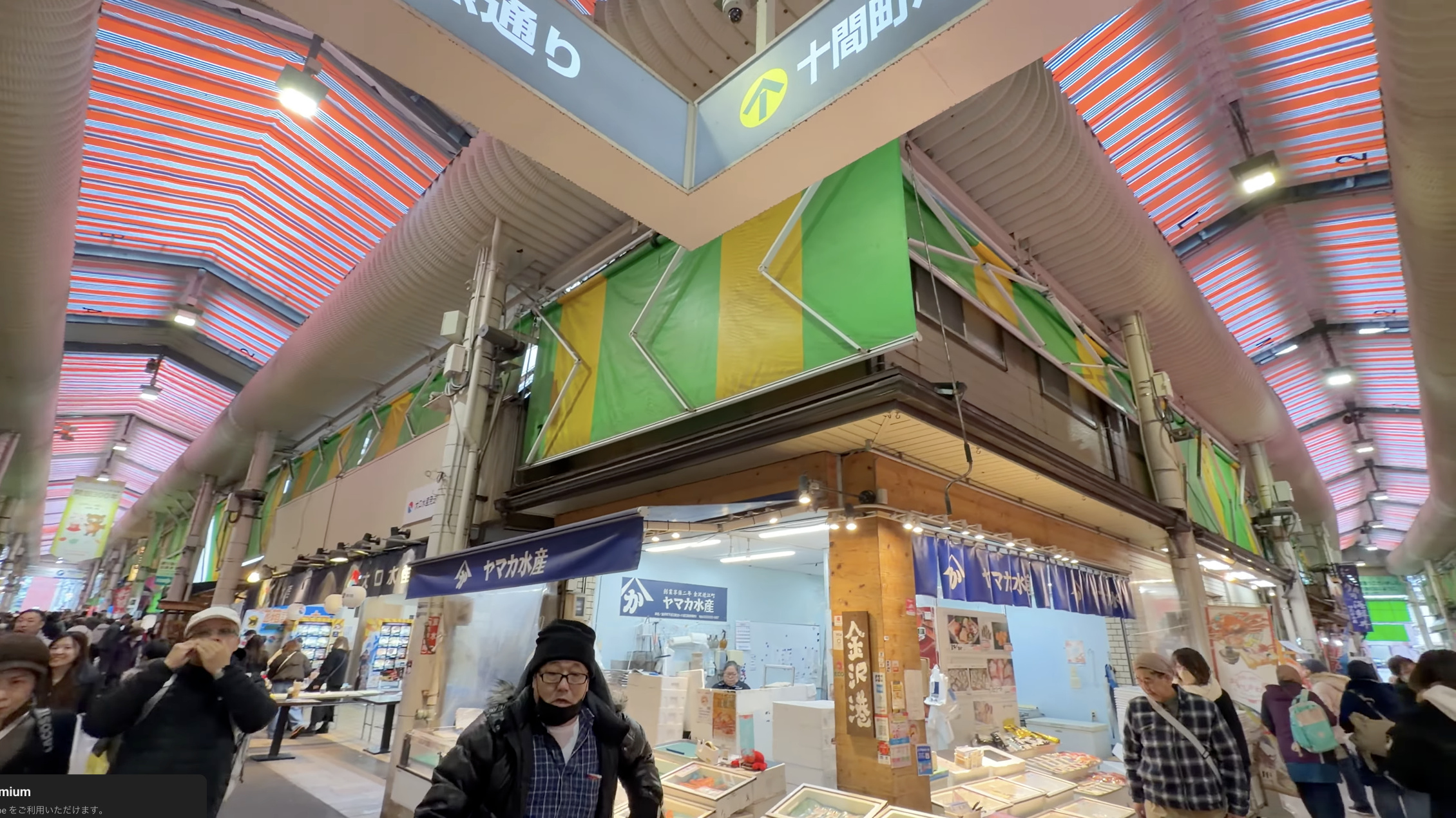「十間町口」「鮮魚通り」の案内看板の下、緑と黄色のテントと「ヤマカ水産」の店先