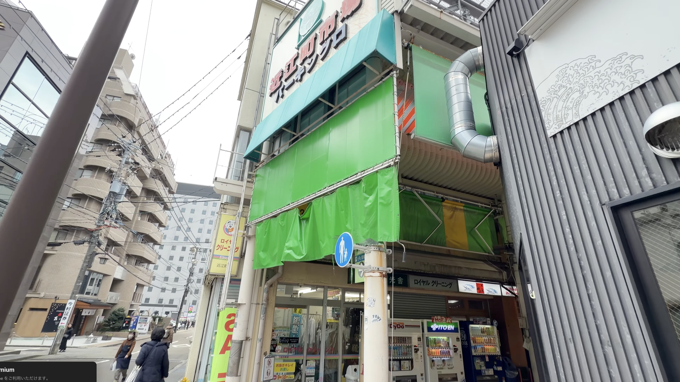 「近江町市場パーキング」の看板が掲げられた建物、1階に「ロイヤルクリーニング」の店先