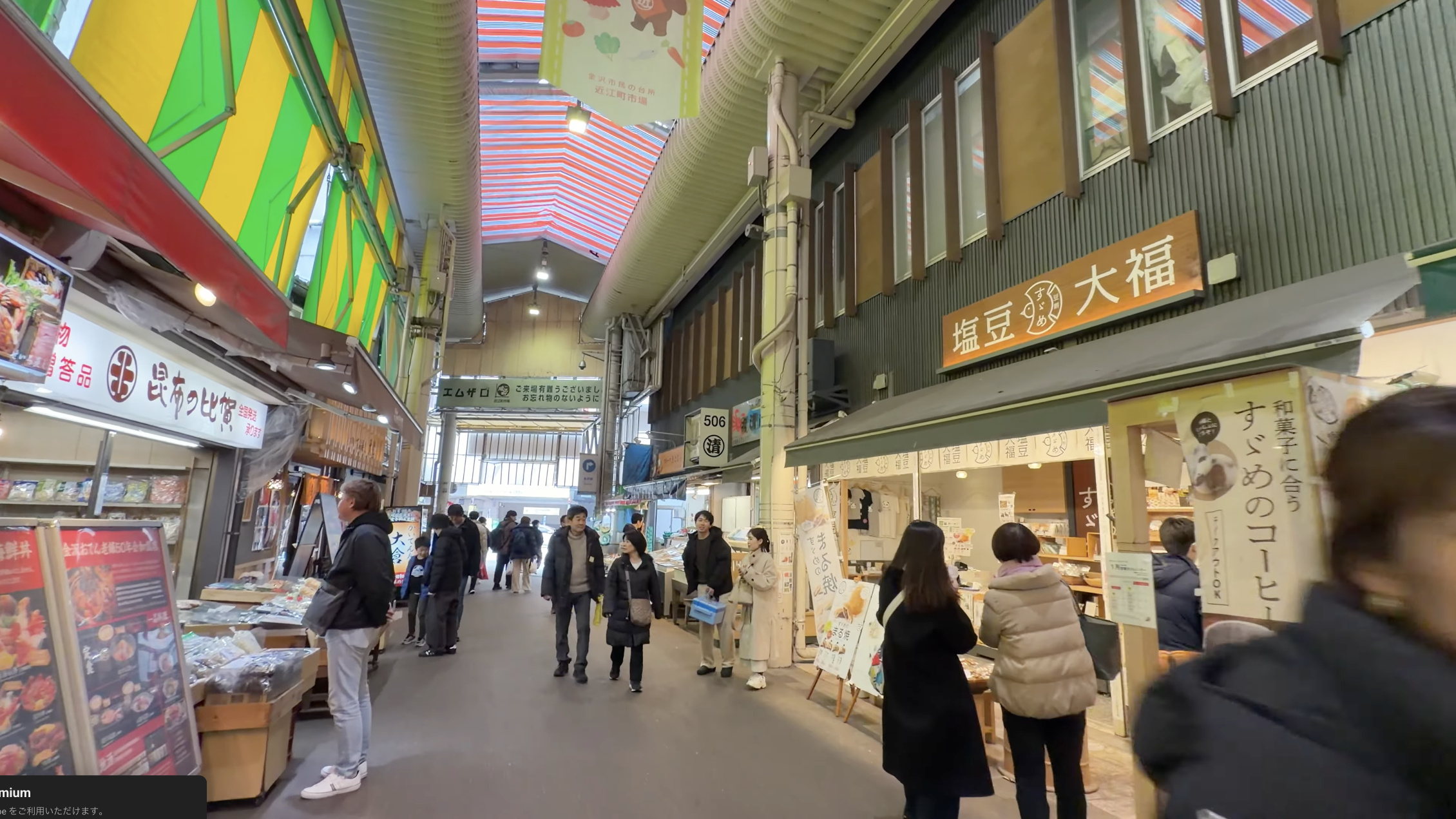 緑と黄色の縞模様のテントが続く鮮魚通り、右手に「塩豆大福」の看板を掲げた和菓子店