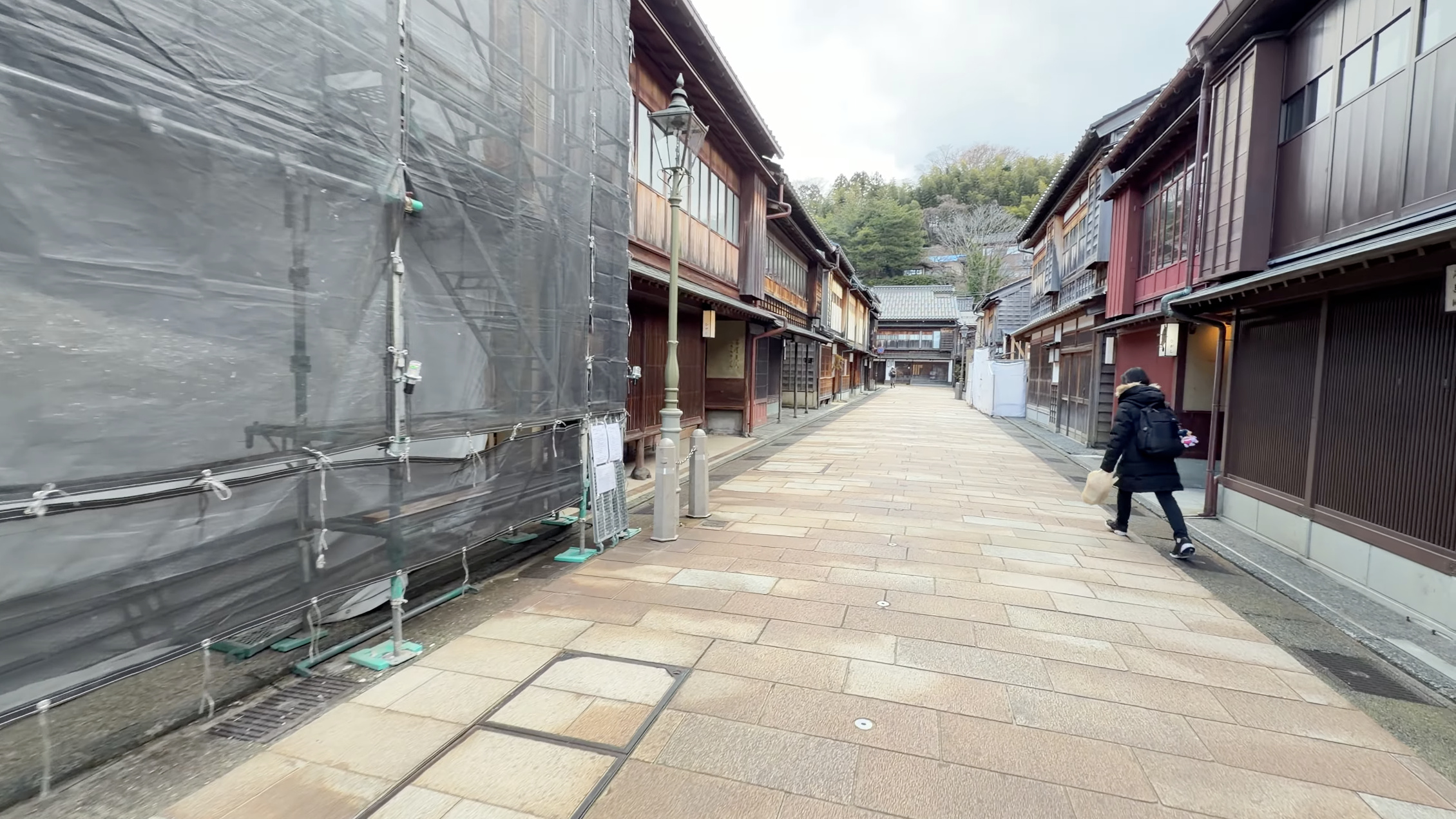 ひがし茶屋街メイン通り、養生シートに覆われた工事中の建物と木造家屋が並ぶ通り