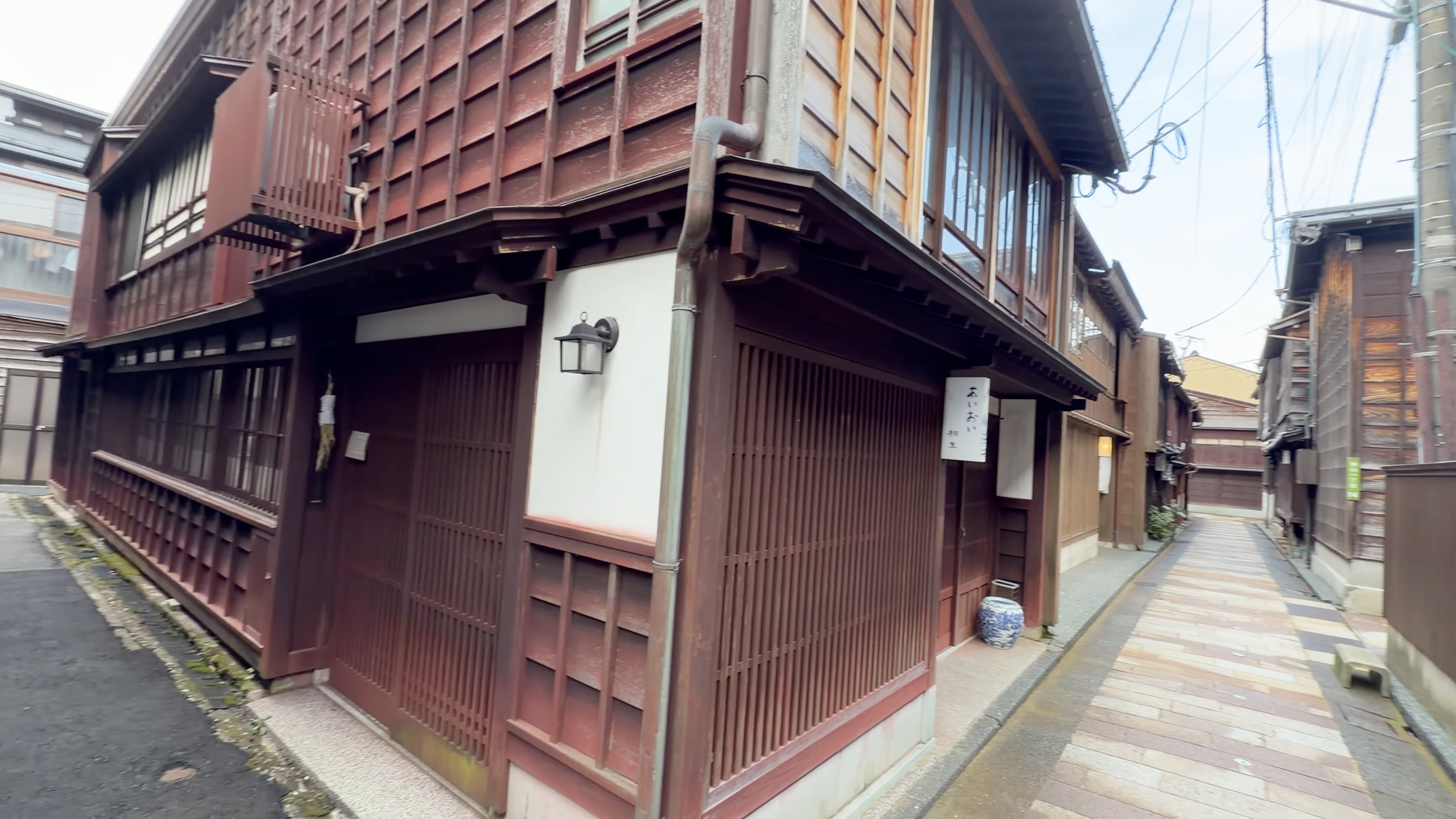 木の壁が続く路地、『KAMU』『Rebekkah』の看板が掛かる建物の入り口