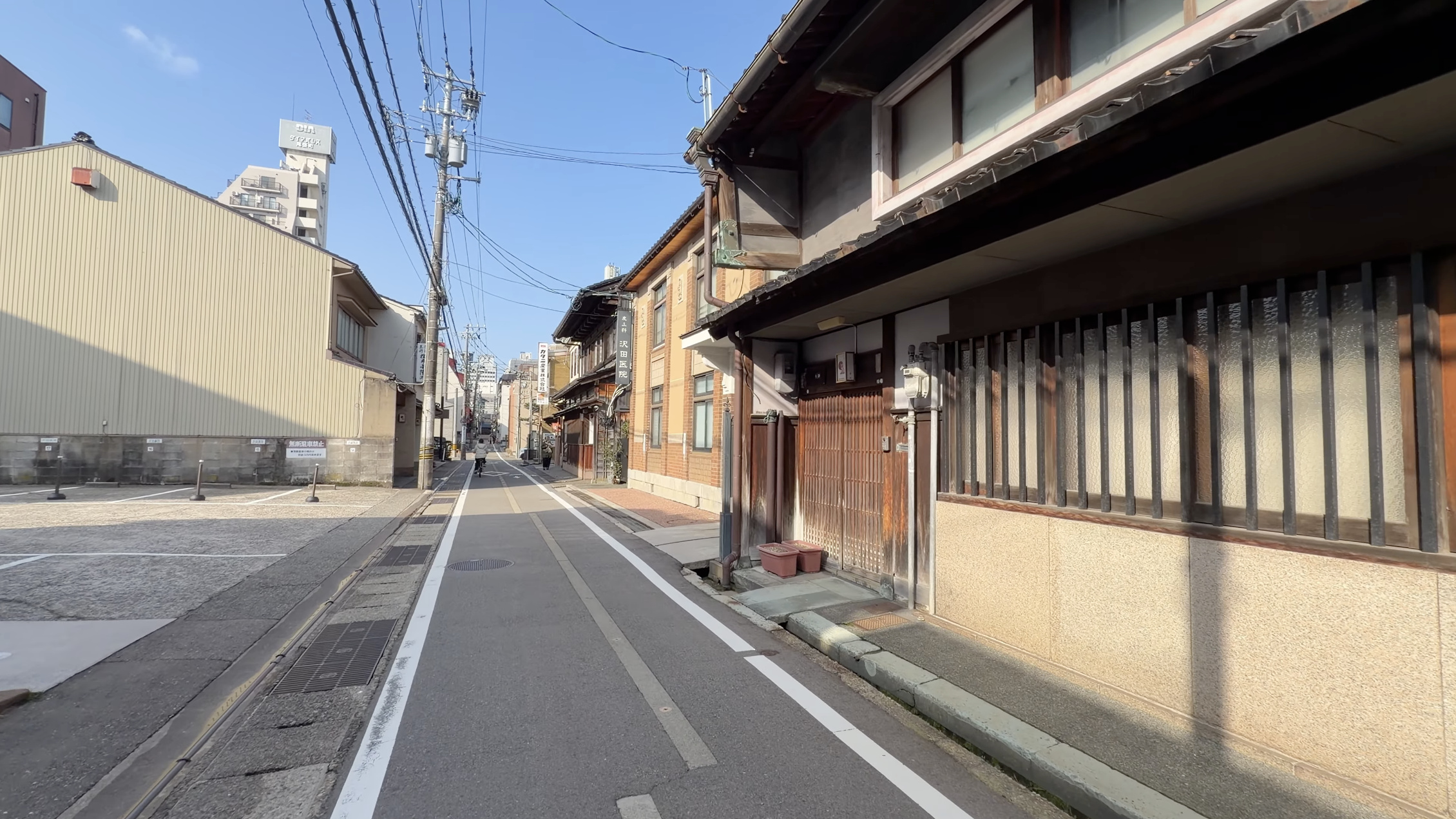 新町・鏡花通り沿いの「沢田医院」の看板、和風の格子戸のある建物、電柱と青空