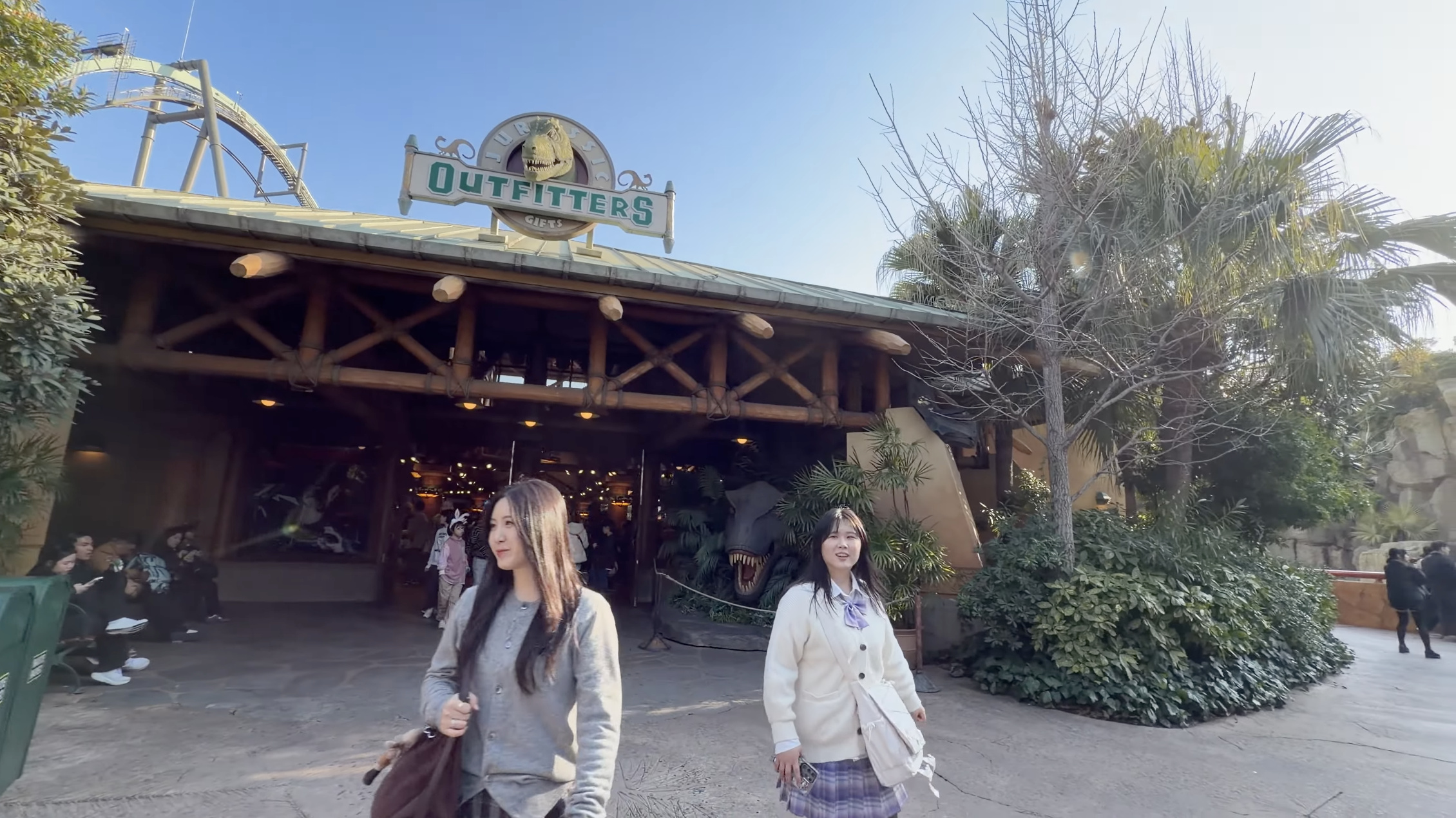 店舗「OUTFITTERS」「GIFTS」、入口のT-Rexの頭のオブジェと木造建物
