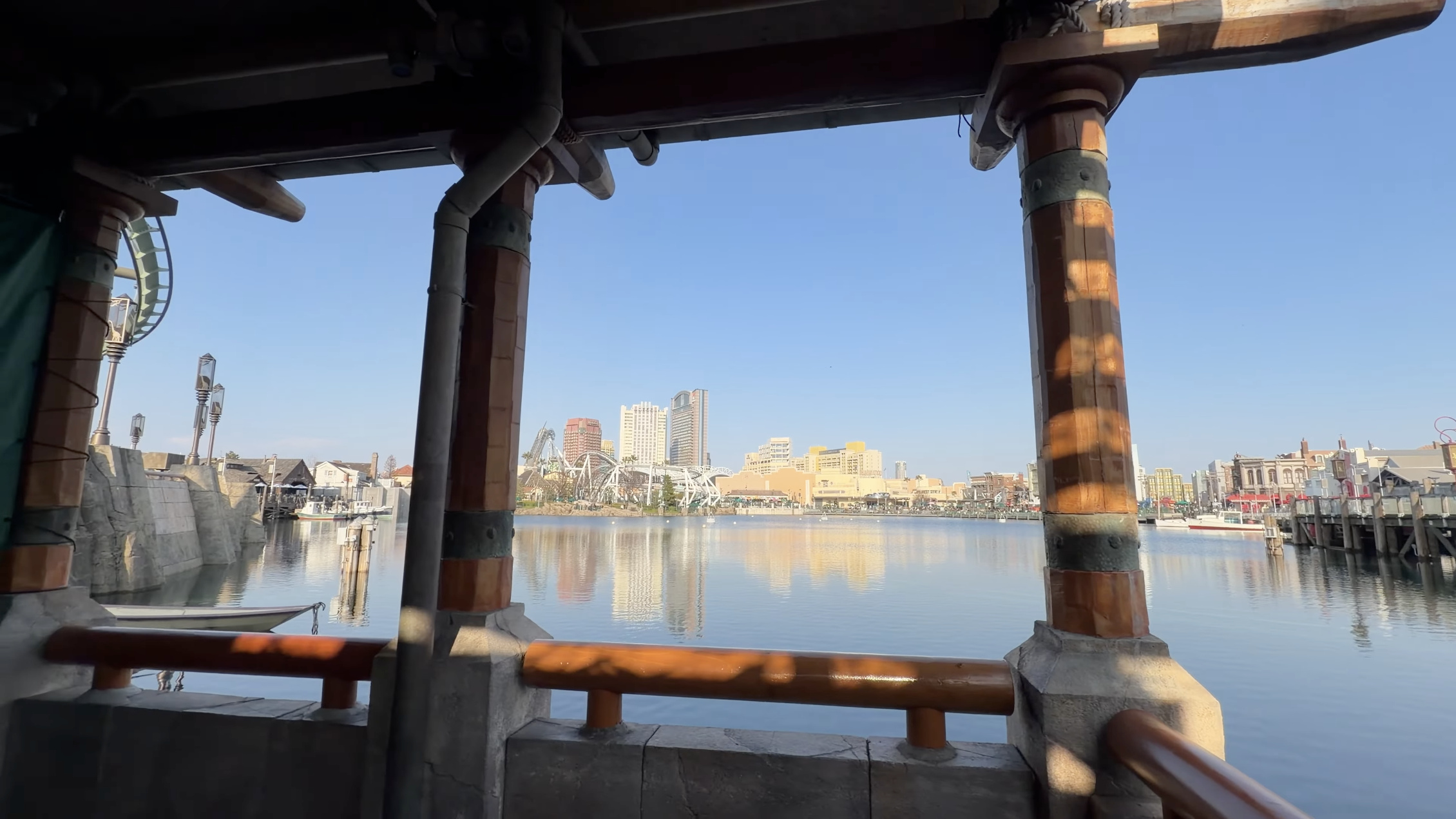 木の柱越しに見える港の景色、対岸の建物群と係留された船
