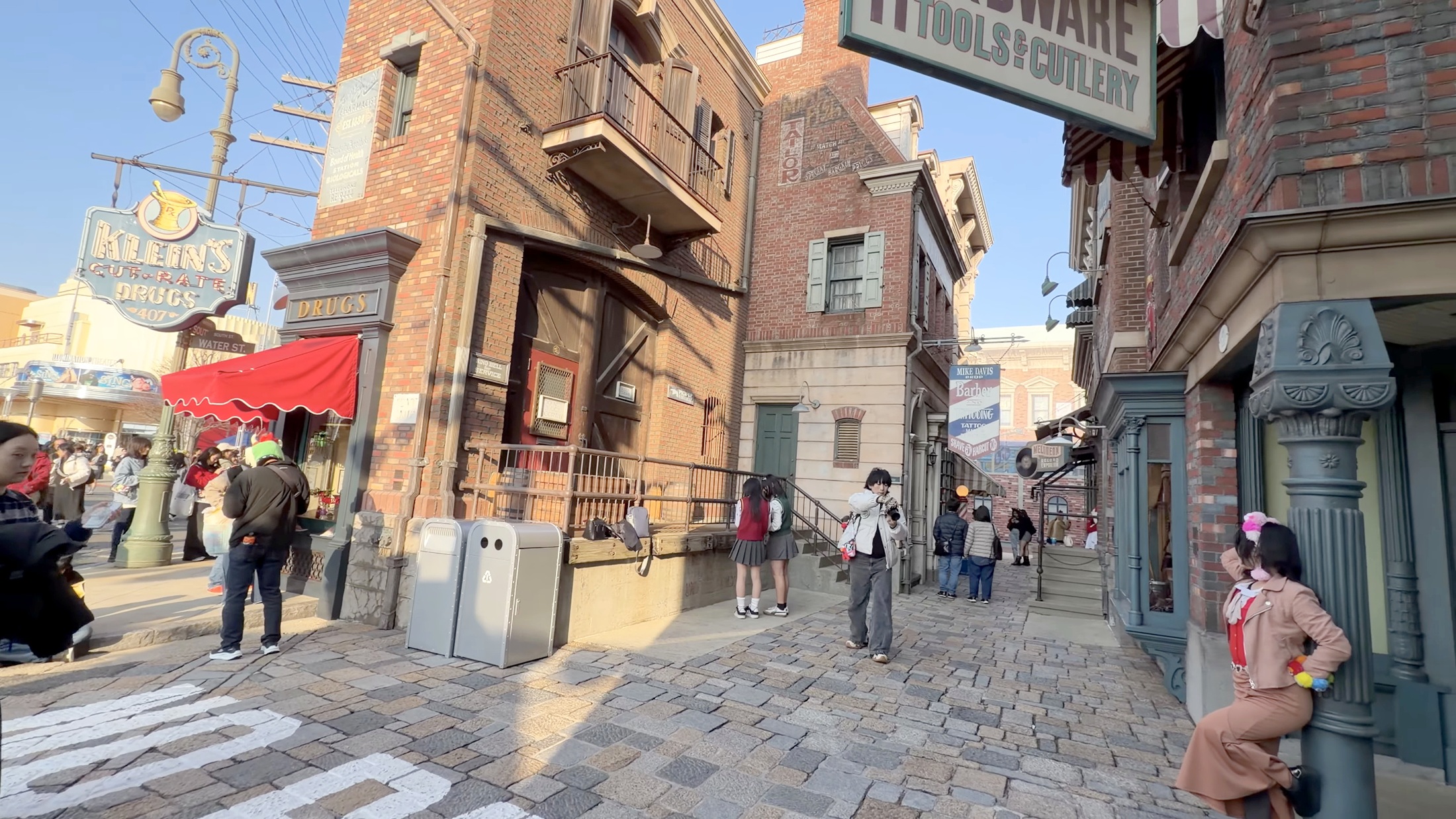 HARDWAREの看板と赤い日除けのドラッグストア
