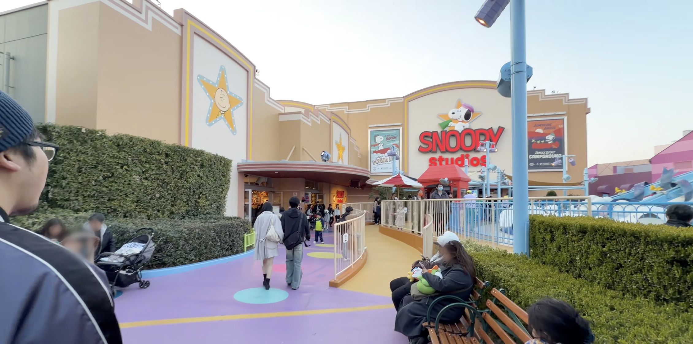 星型の看板に描かれたチャーリー・ブラウン、紫色の歩道とSNOOPY studiosの入口