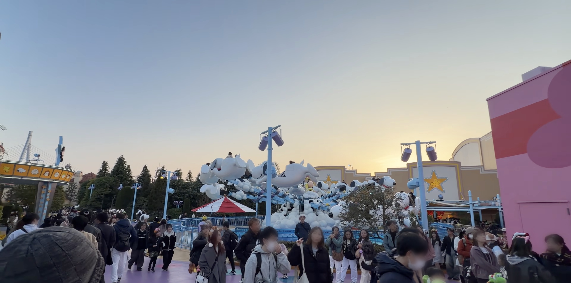 夕焼け空の下、白いスヌーピー型の乗り物フライング・スヌーピー