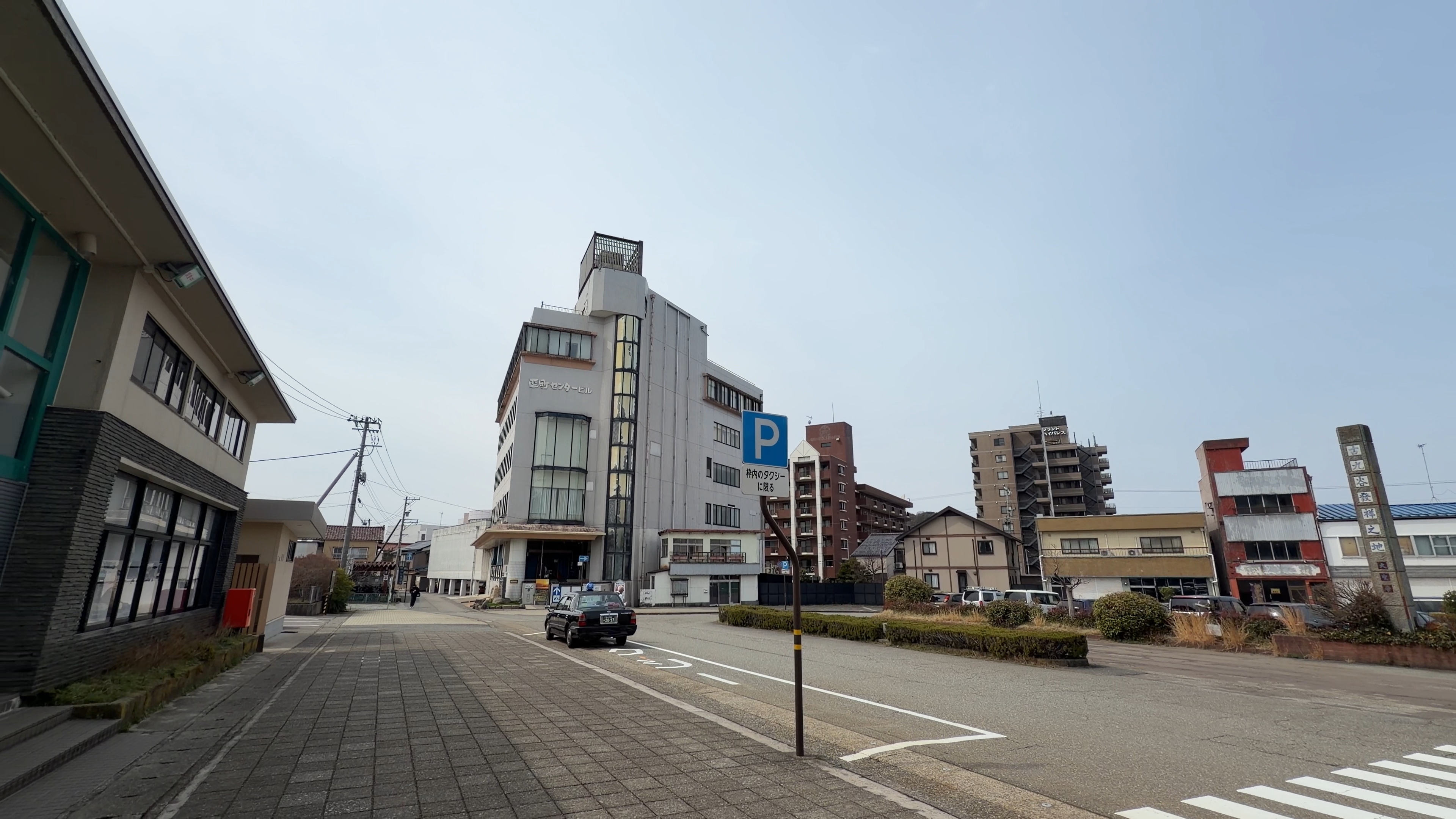 大聖寺駅前から続く通り、古い商店ビルとタクシーが並ぶまち並み