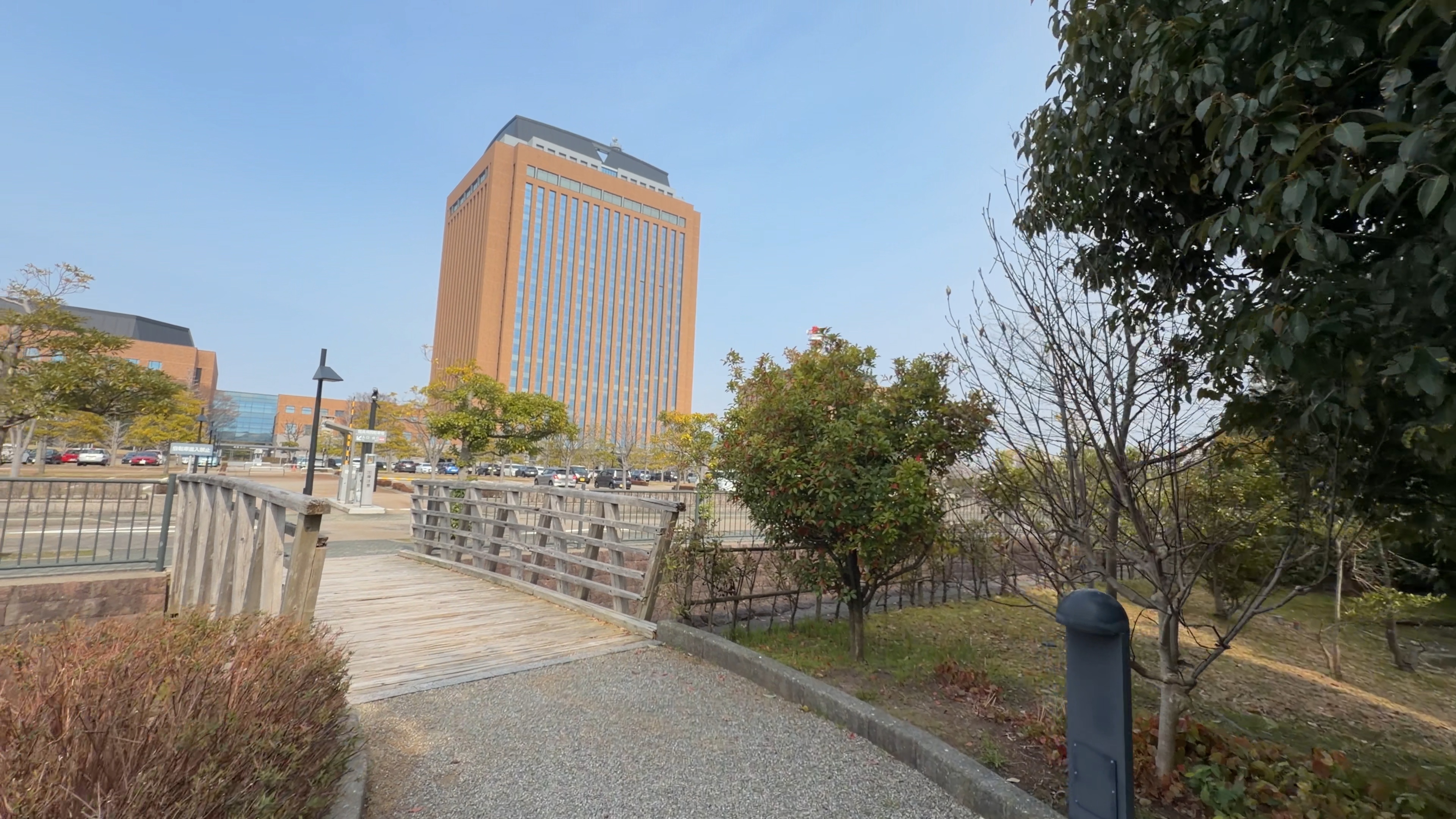 木の橋、正面に19階建ての行政庁舎