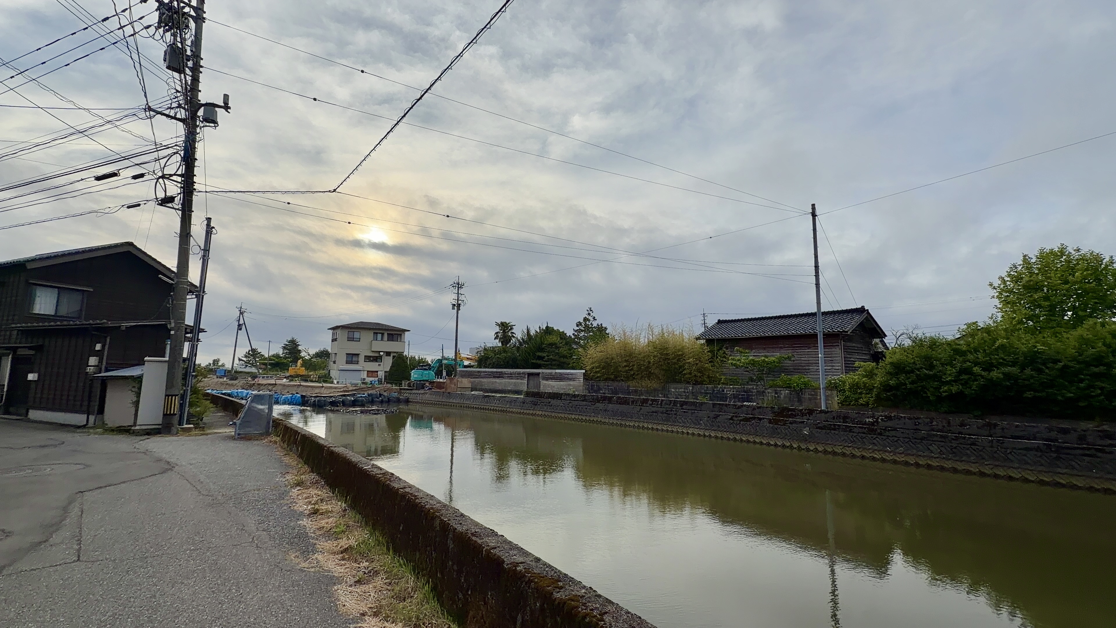 松波川沿いの道・水面に建物が映る