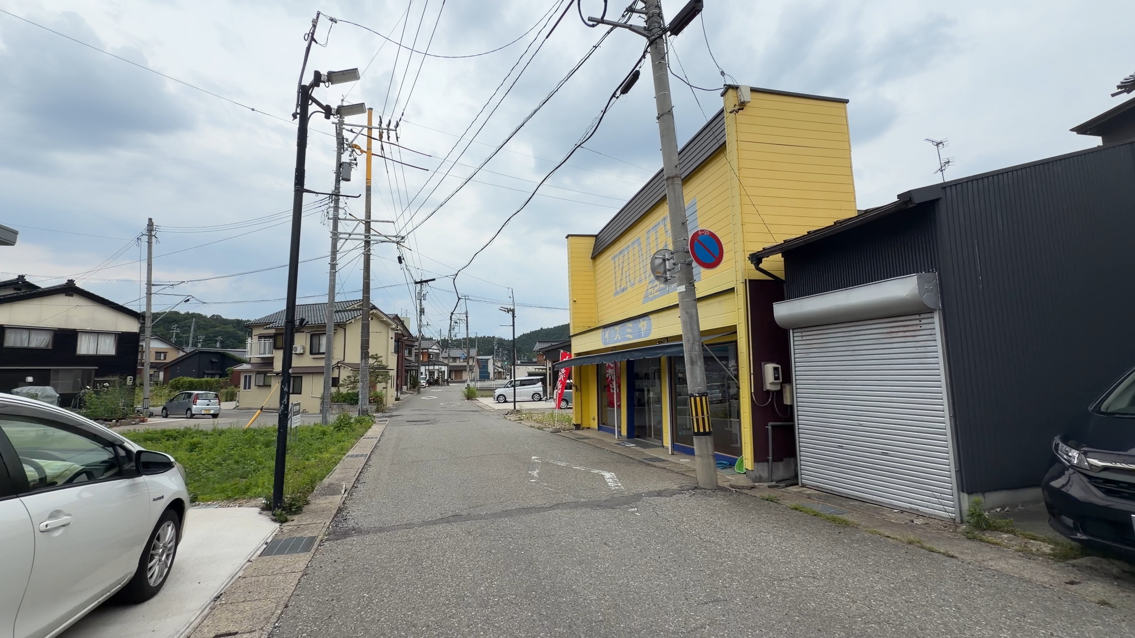 黄色い外壁の靴店「イズミヤ」の建物