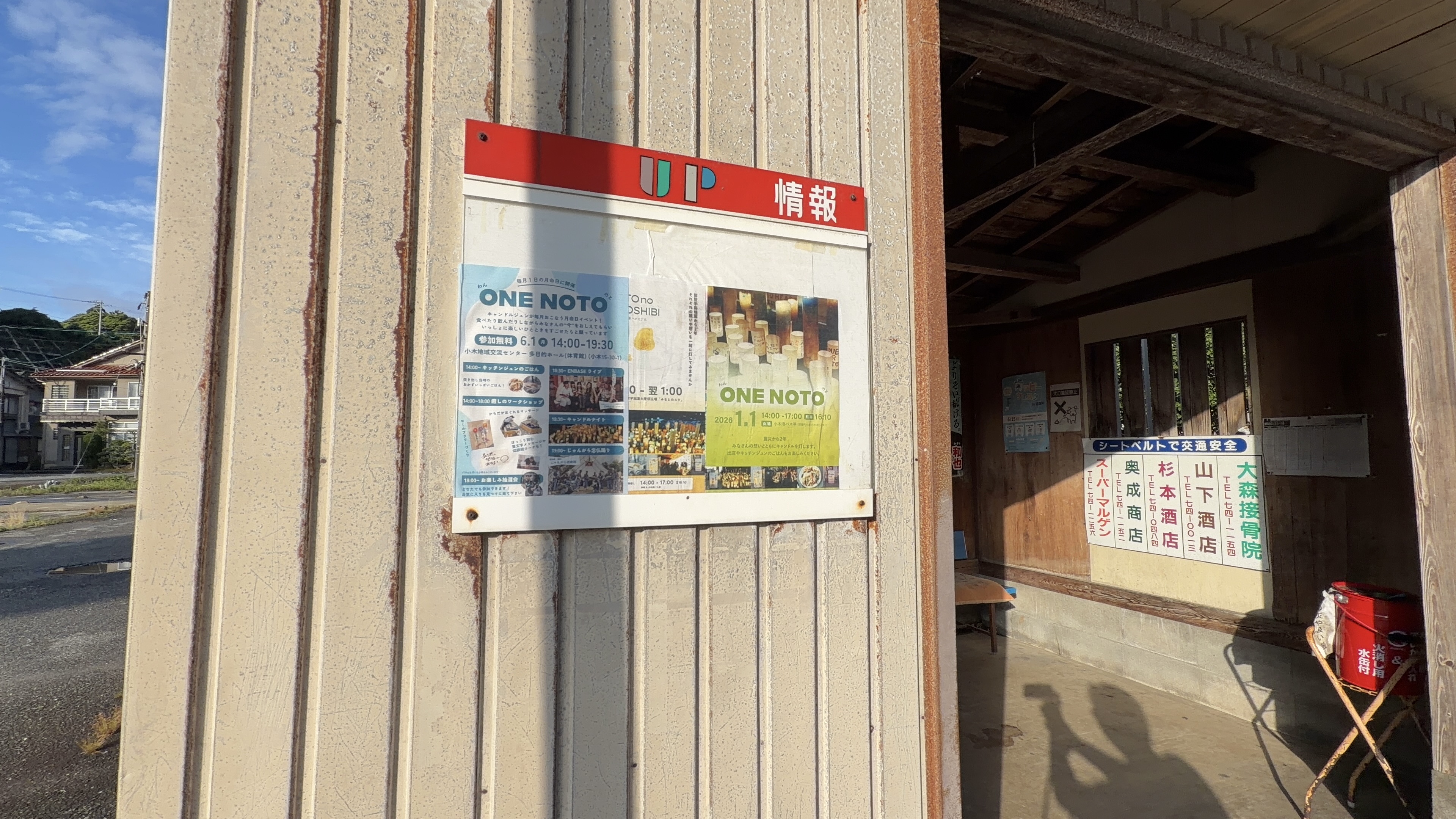 バス停休憩所のUP情報掲示板とONE NOTOのポスター