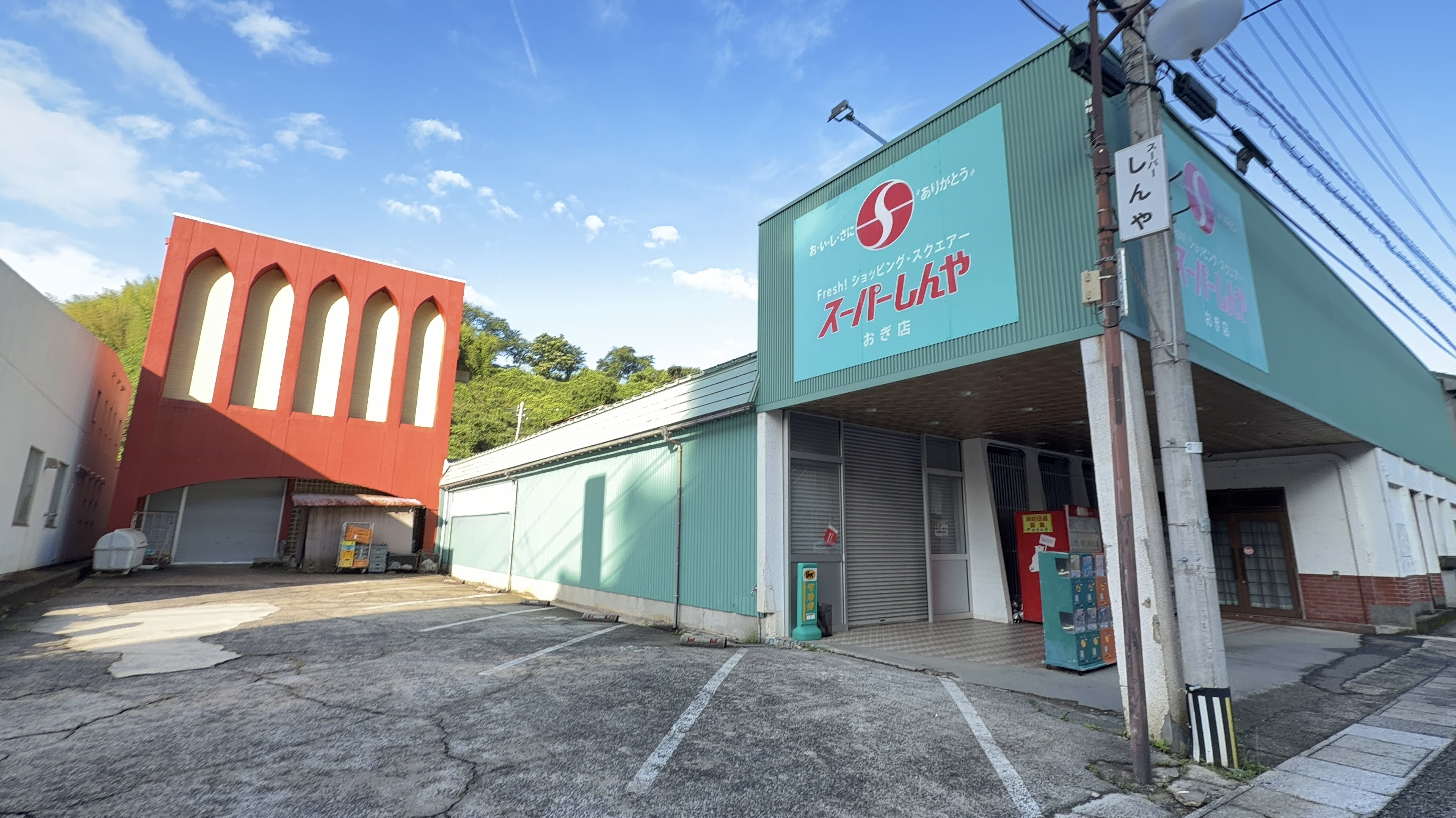 緑の建物の現スーパーしんや おぎ店