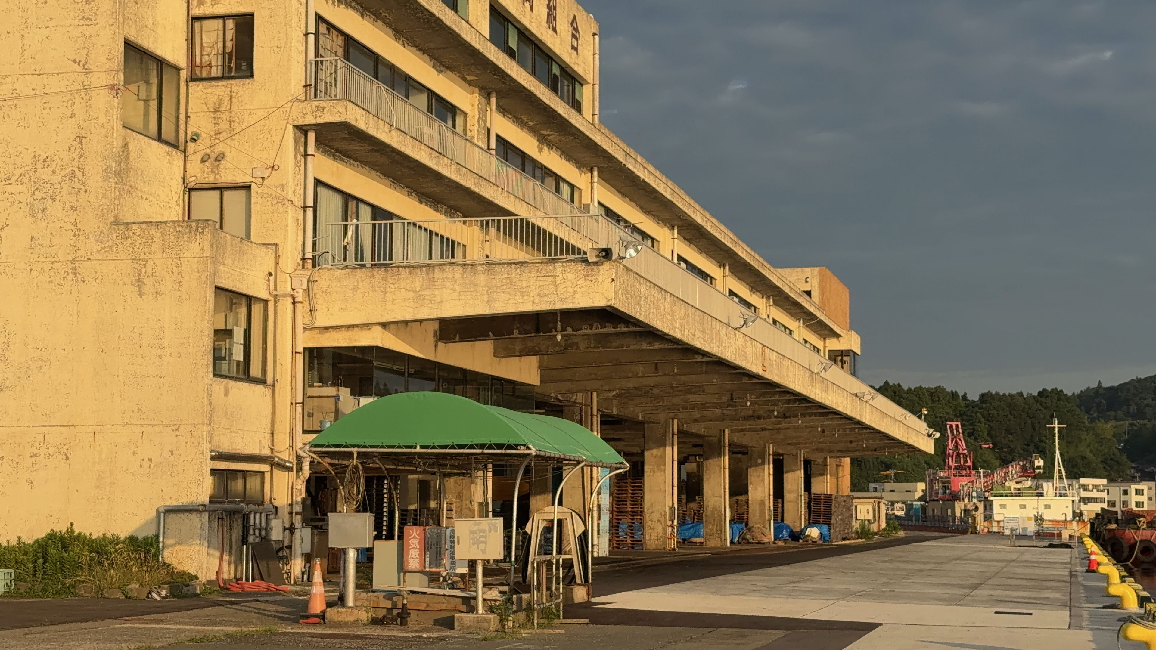 朝日に照らされる小木漁協の大きな建物