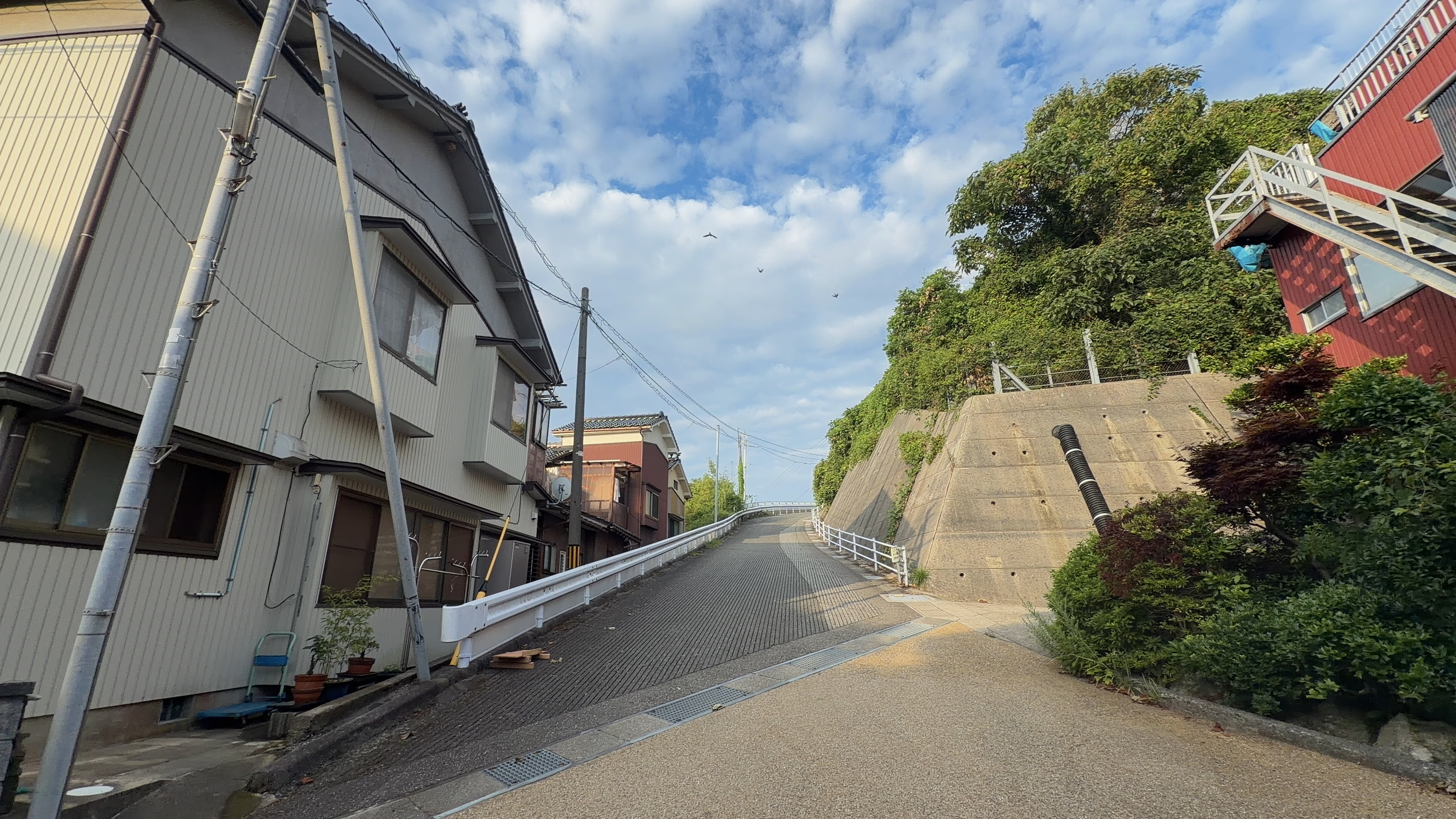 コンクリートの擁壁が続く小木の坂道