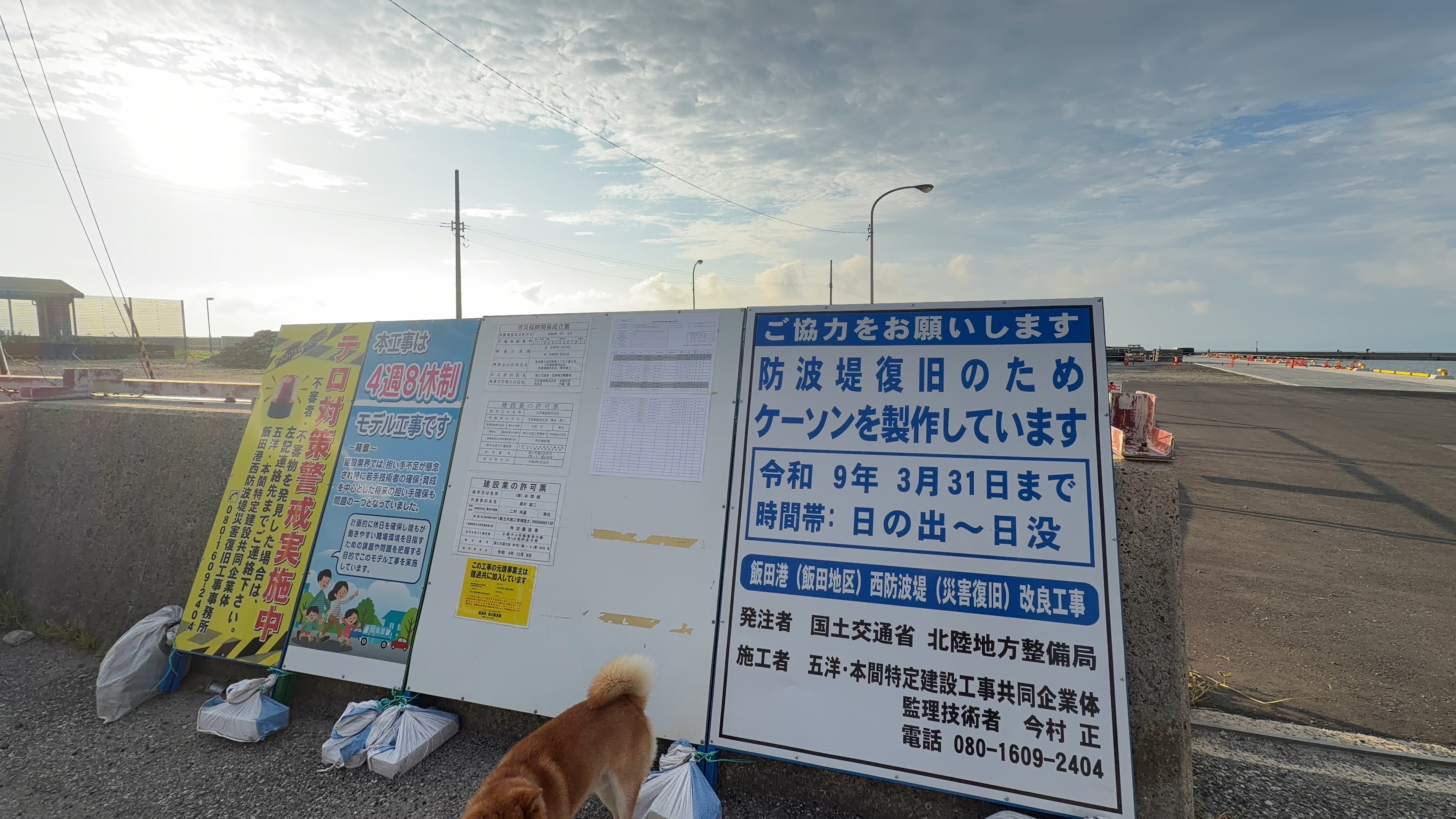 防波堤復旧のケーソン製作を知らせる工事看板とたろーさん
