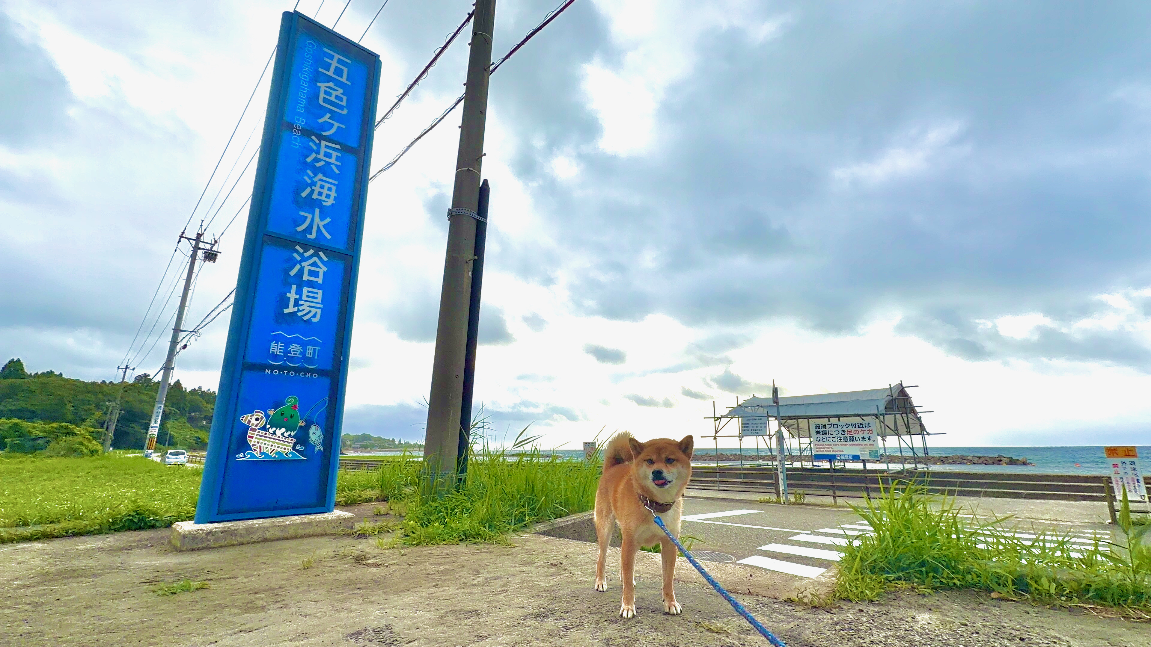 五色ケ浜海水浴場の看板の前で振り返るたろーさん