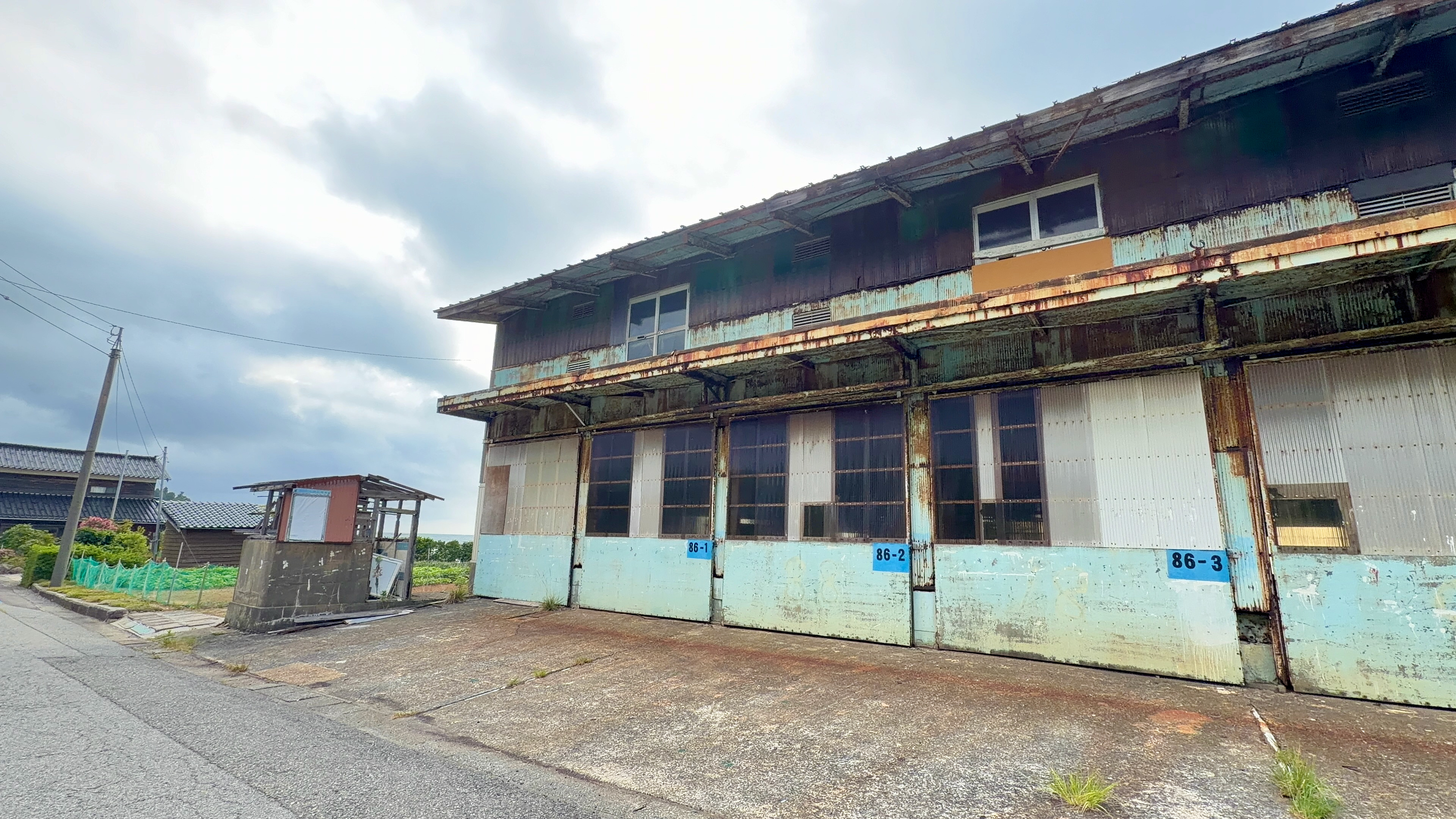 86-1、86-2、86-3と番号のふられたトタン張りの大きな倉庫