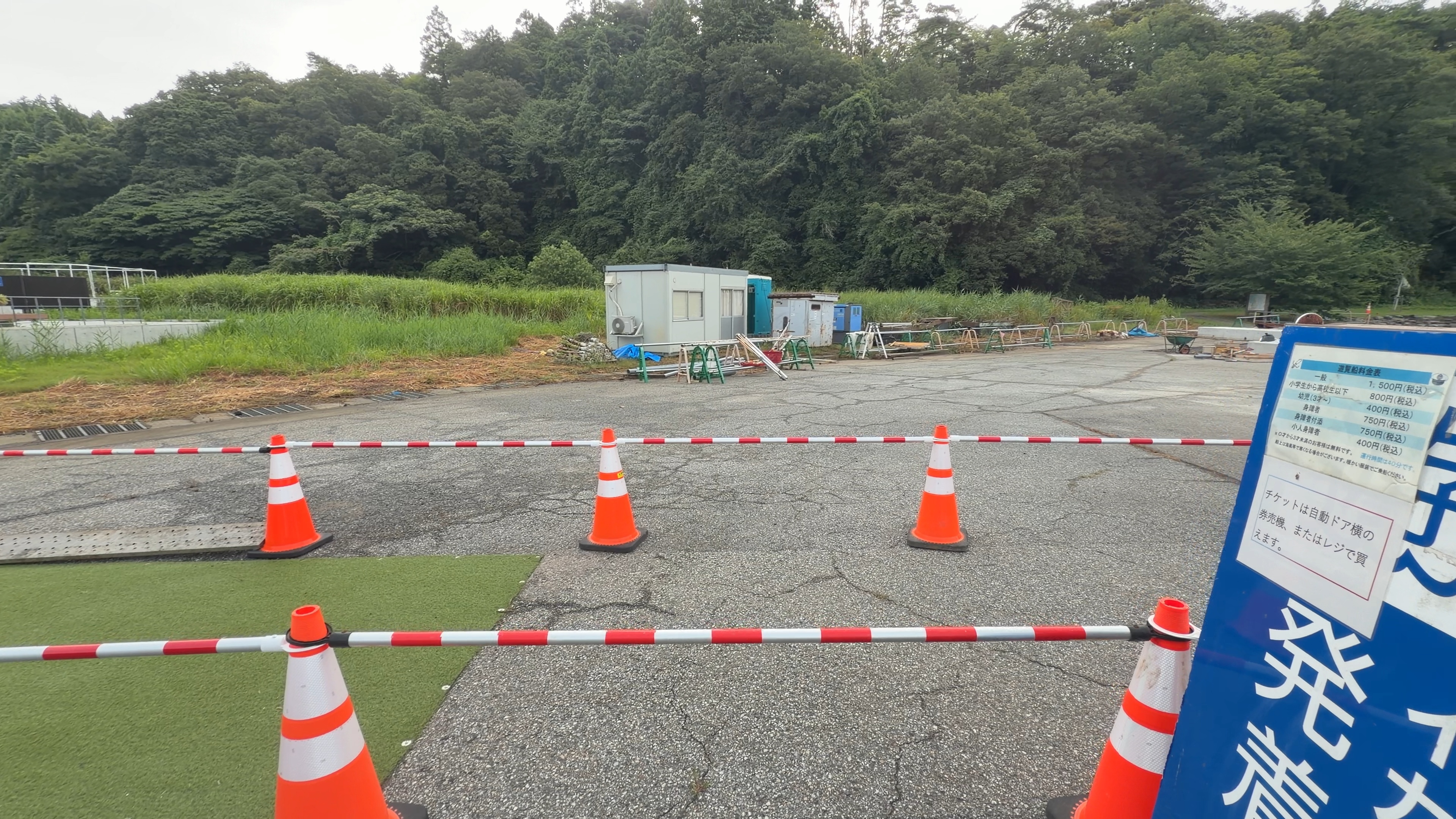 水中観光船の料金表と、コーンで区切られた乗り場前の広場