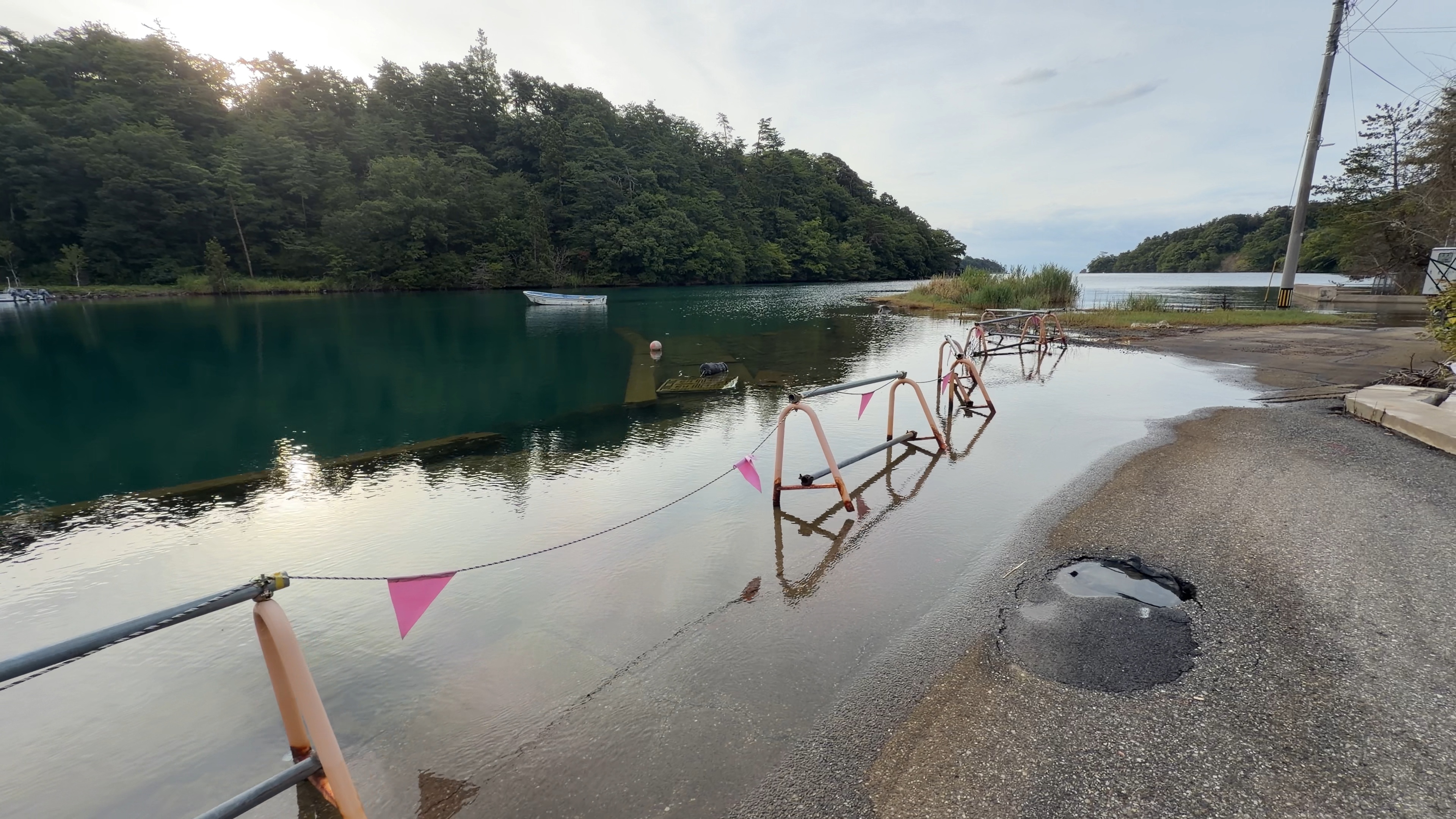 住宅街に沿った道が水に浸かっている様子、朝の高潮