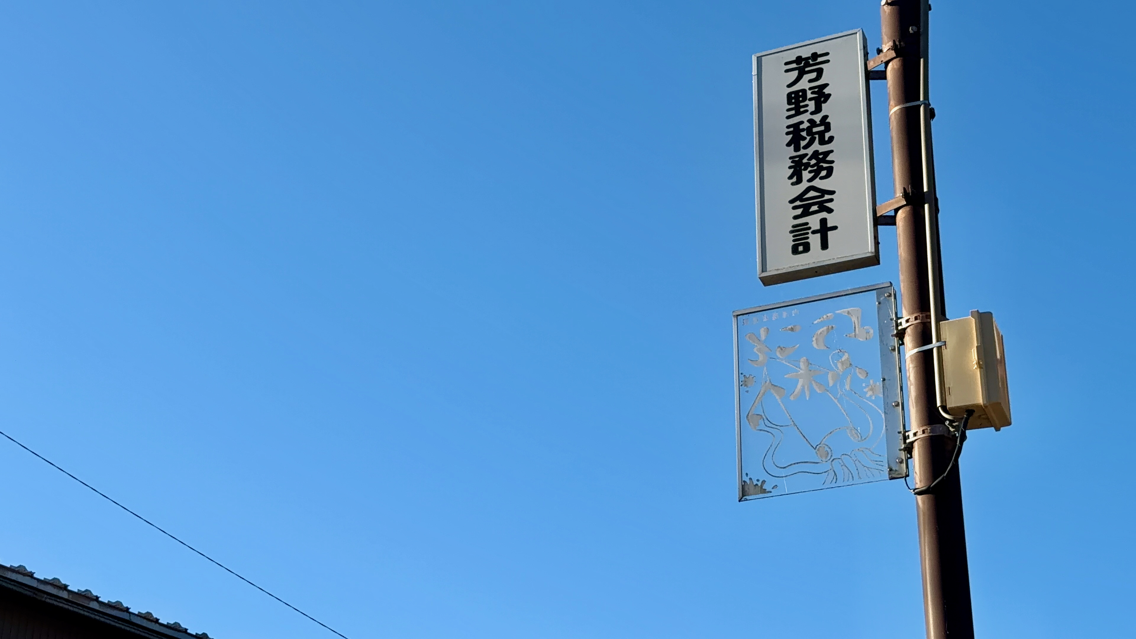 芳野税務会計の看板と、いかのイラスト案内板