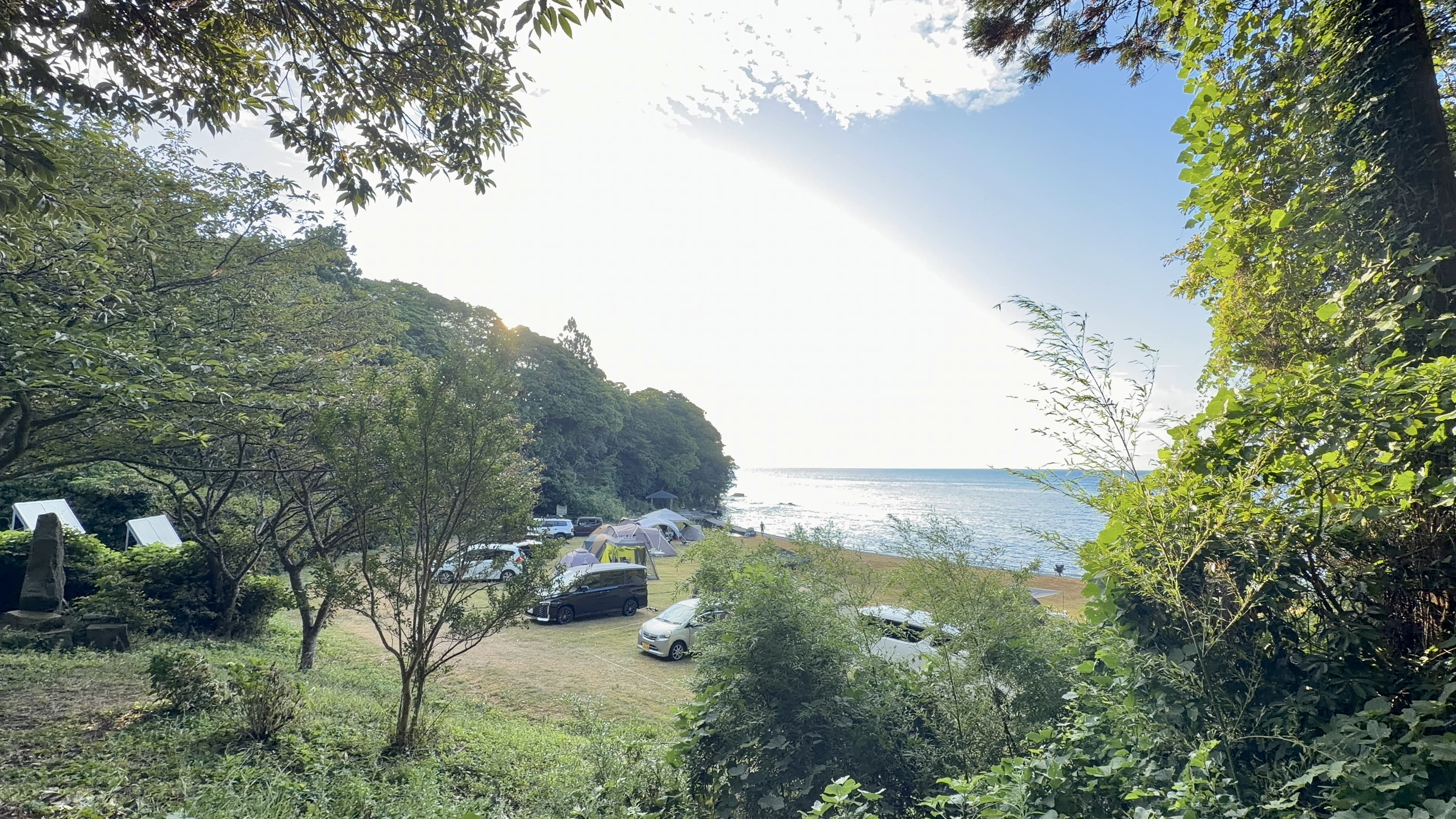 木々の間から見下ろす九十九湾キャンプ場とテント、海