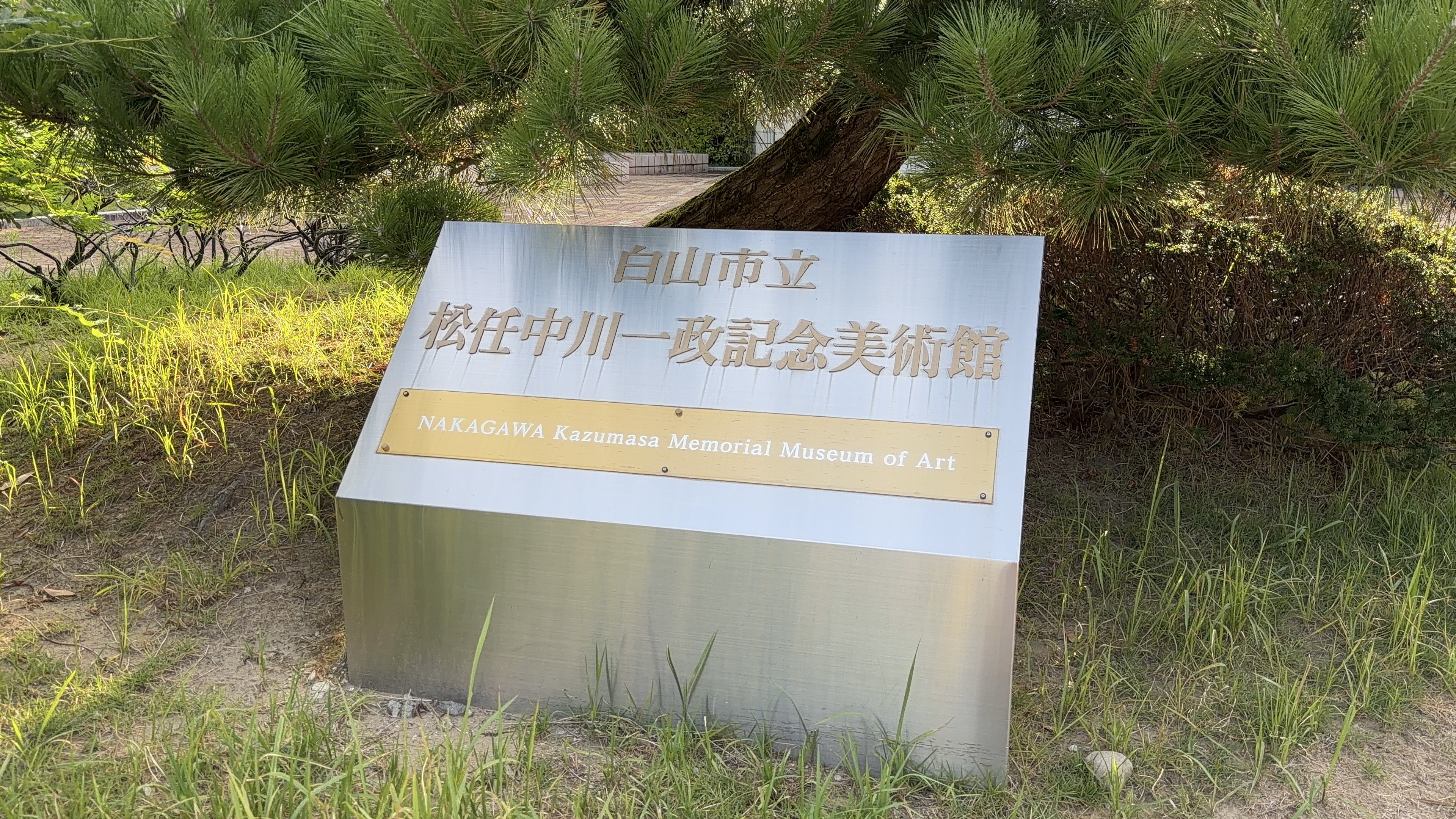 「白山市立 松任中川一政記念美術館 NAKAGAWA Kazumasa Memorial Museum of Art」の銘板、松の木の下