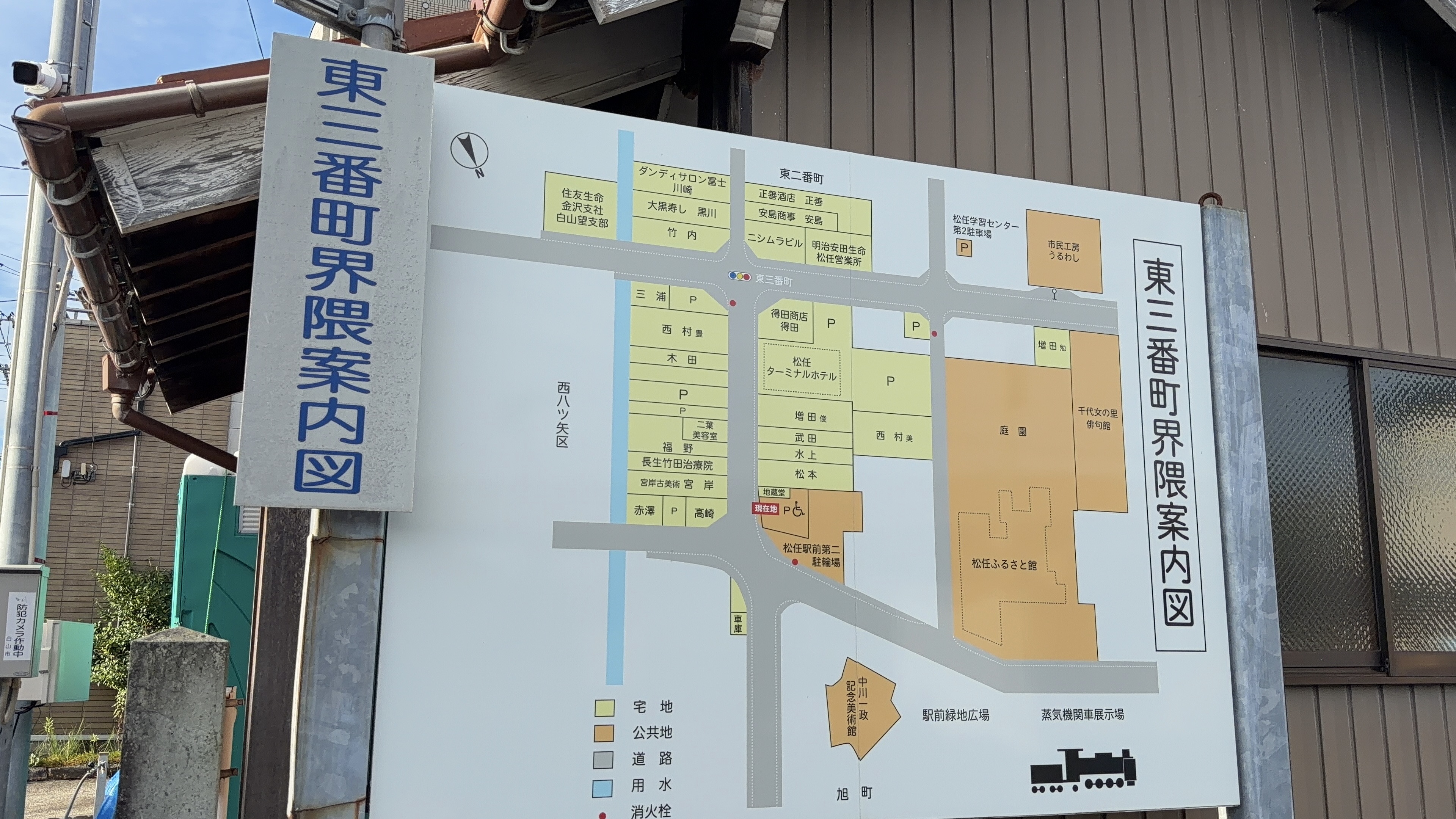 「東二番町界隈案内図」の看板、松任ふるさと館・中川一政記念美術館・千代女の里俳句館・蒸気機関車展示場などが描かれた地図
