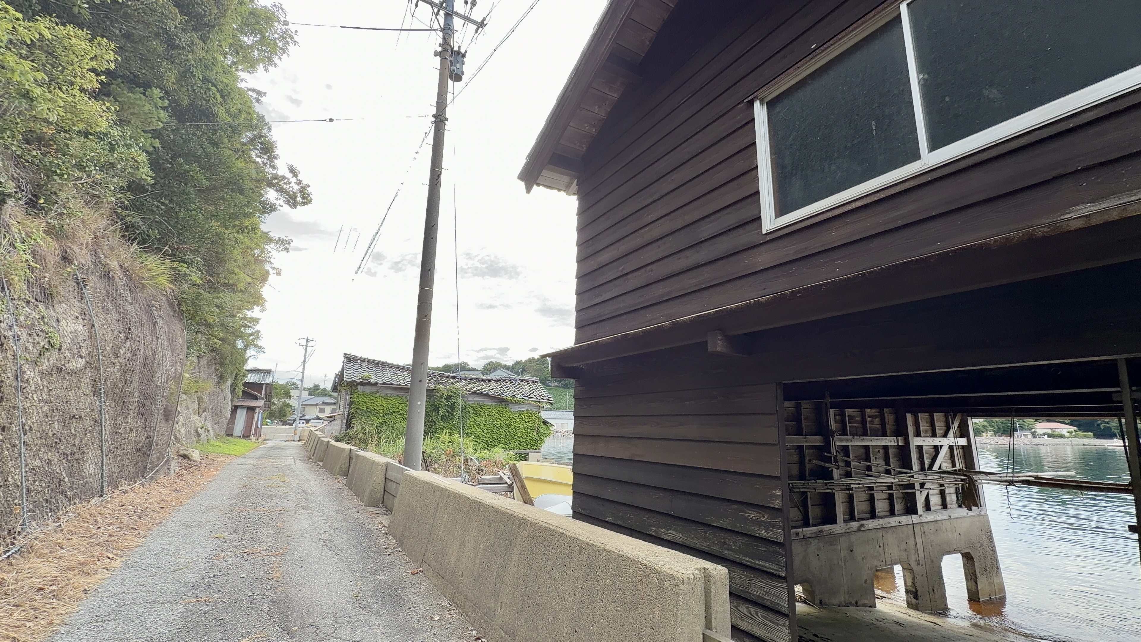 船小屋通りの小道と、板張りの船小屋の外観