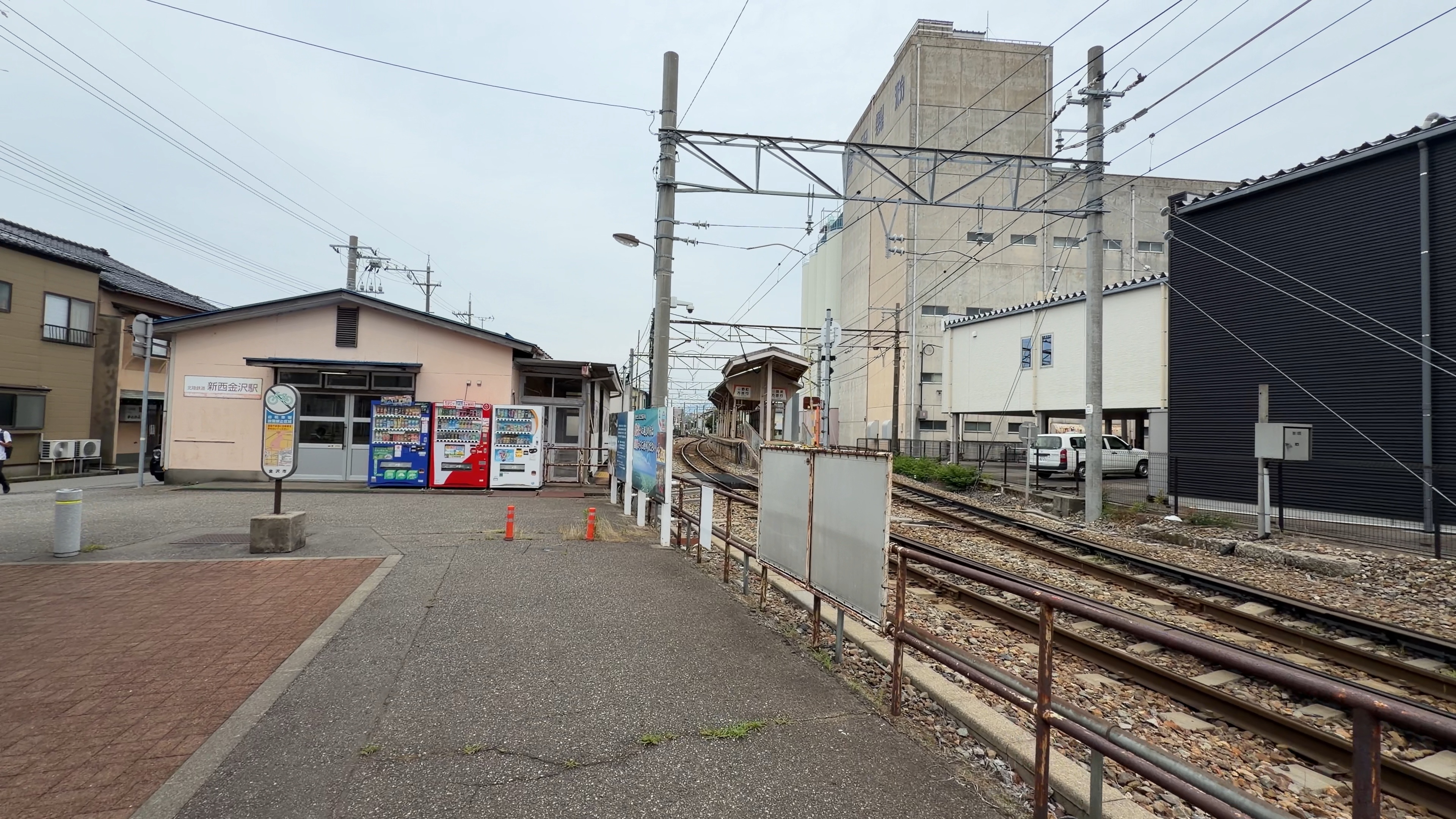 北陸鉄道 新西金沢駅の駅舎、ピンク色の外壁と自動販売機