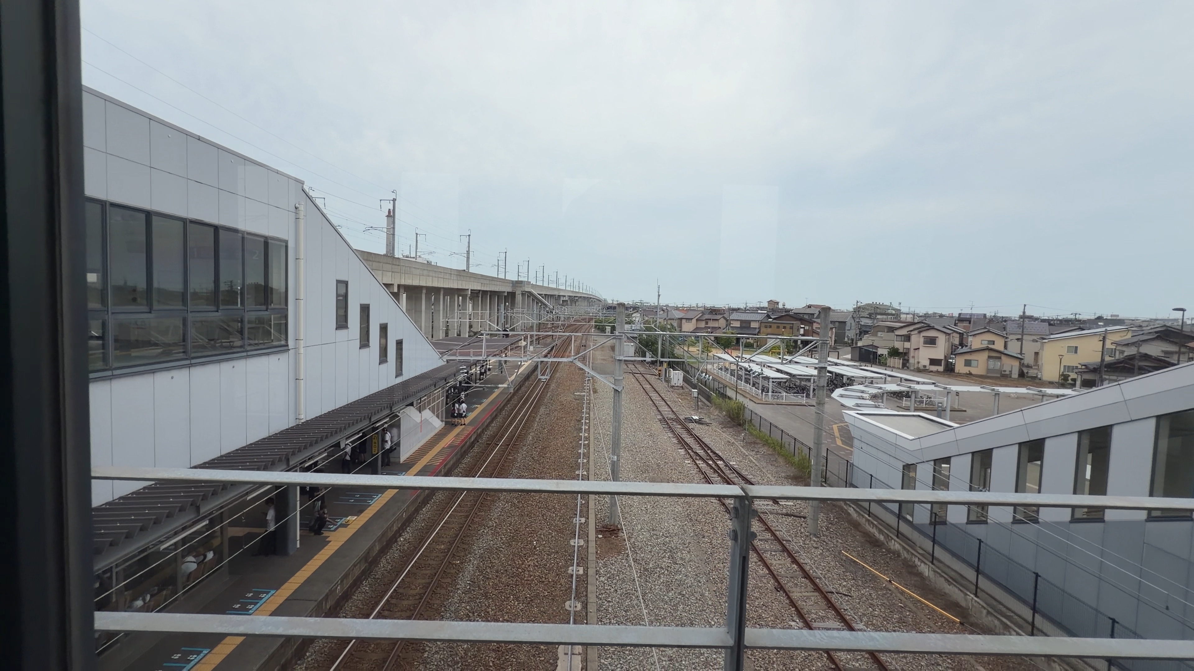 西金沢駅の自由通路から見下ろすホームと線路、屋根の続く風景