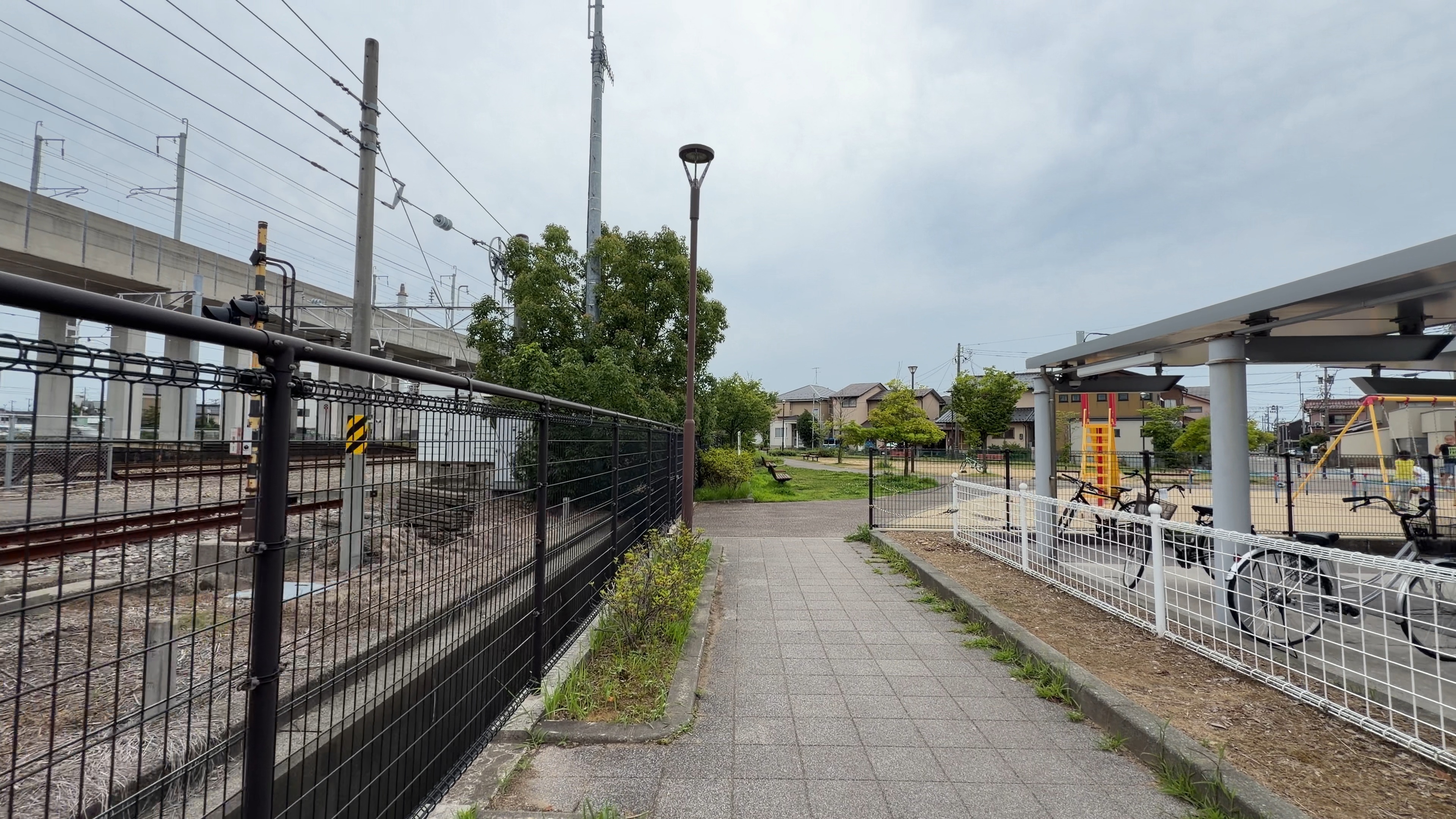 西金沢駅横の大きな駐輪場と、高架橋越しに見える住宅街
