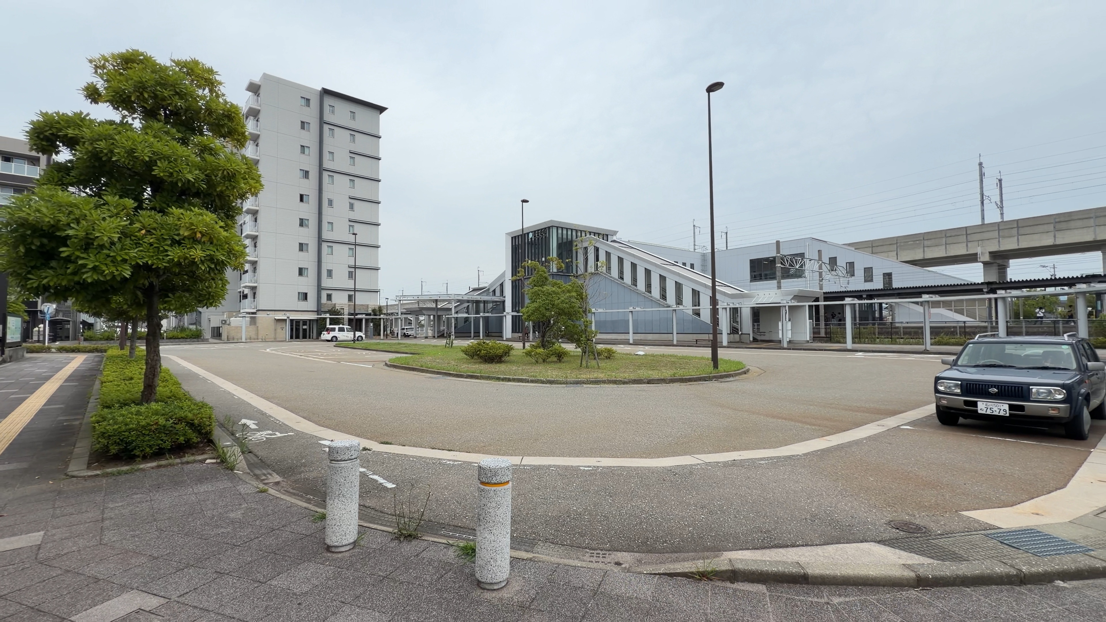 西金沢駅前のロータリー全景、高層マンションと駅舎