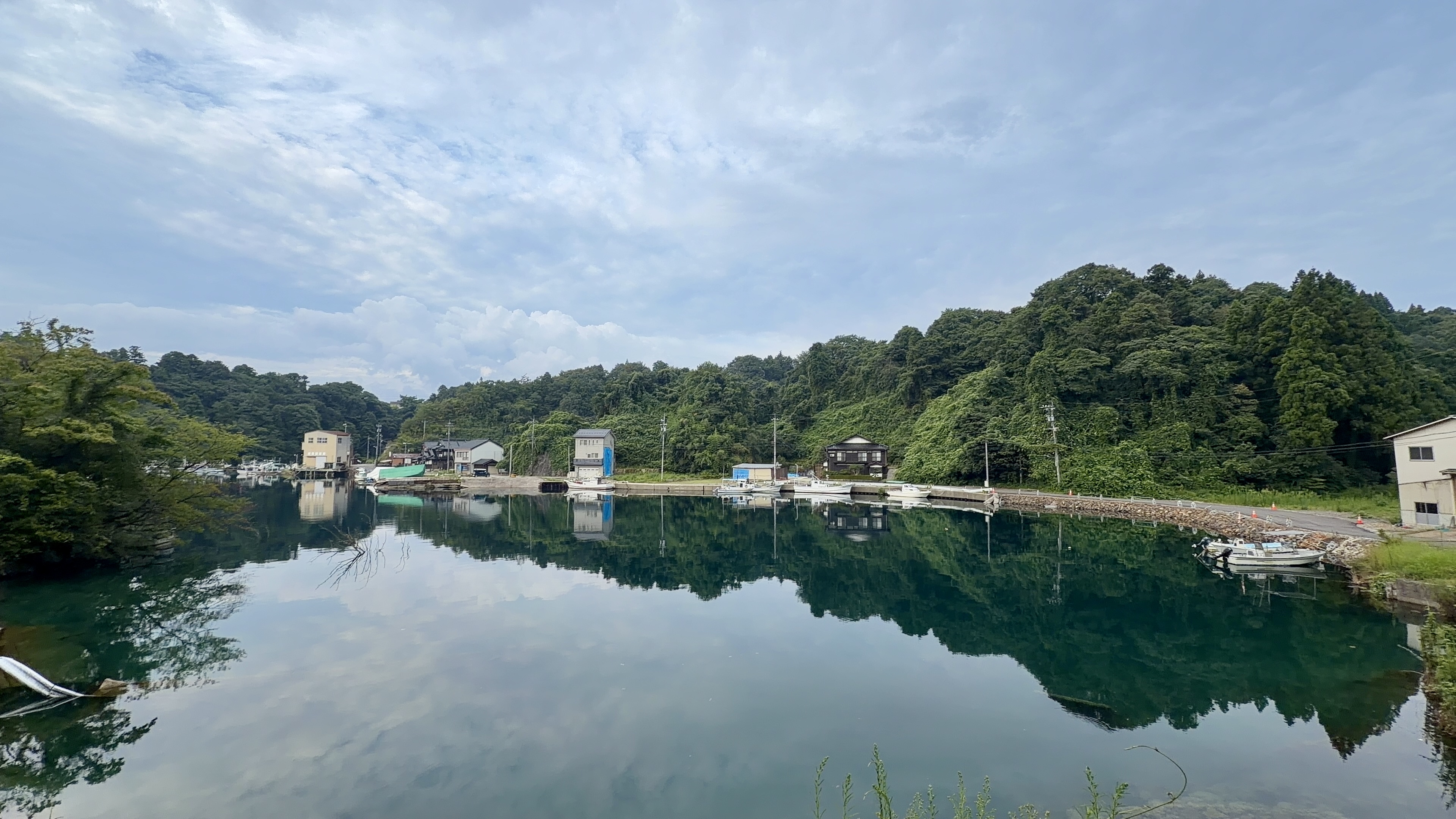 波ひとつない奈古浦の入江、対岸の家や山がそのまま映る朝の水面