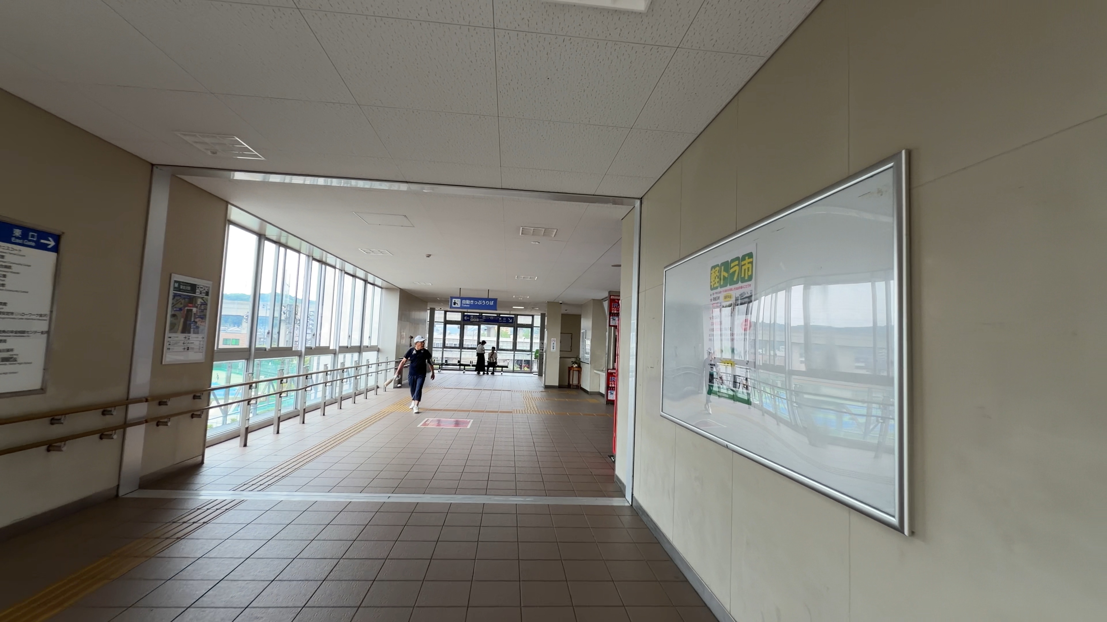 自由通路の内部、まっすぐ続く通路と歩いている人、掲示板