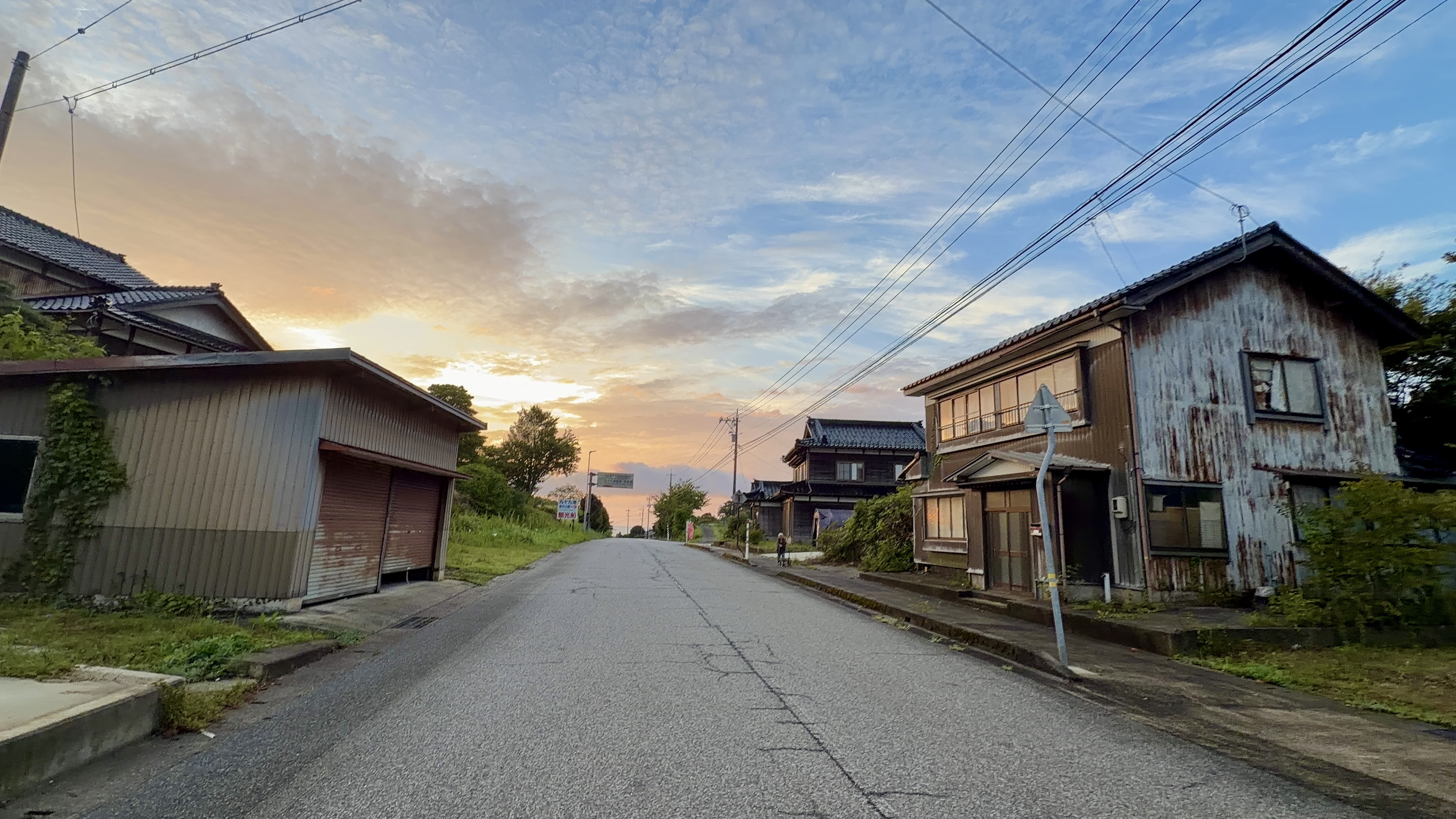 誰もいない朝の集落の通り、古い家々が並ぶ