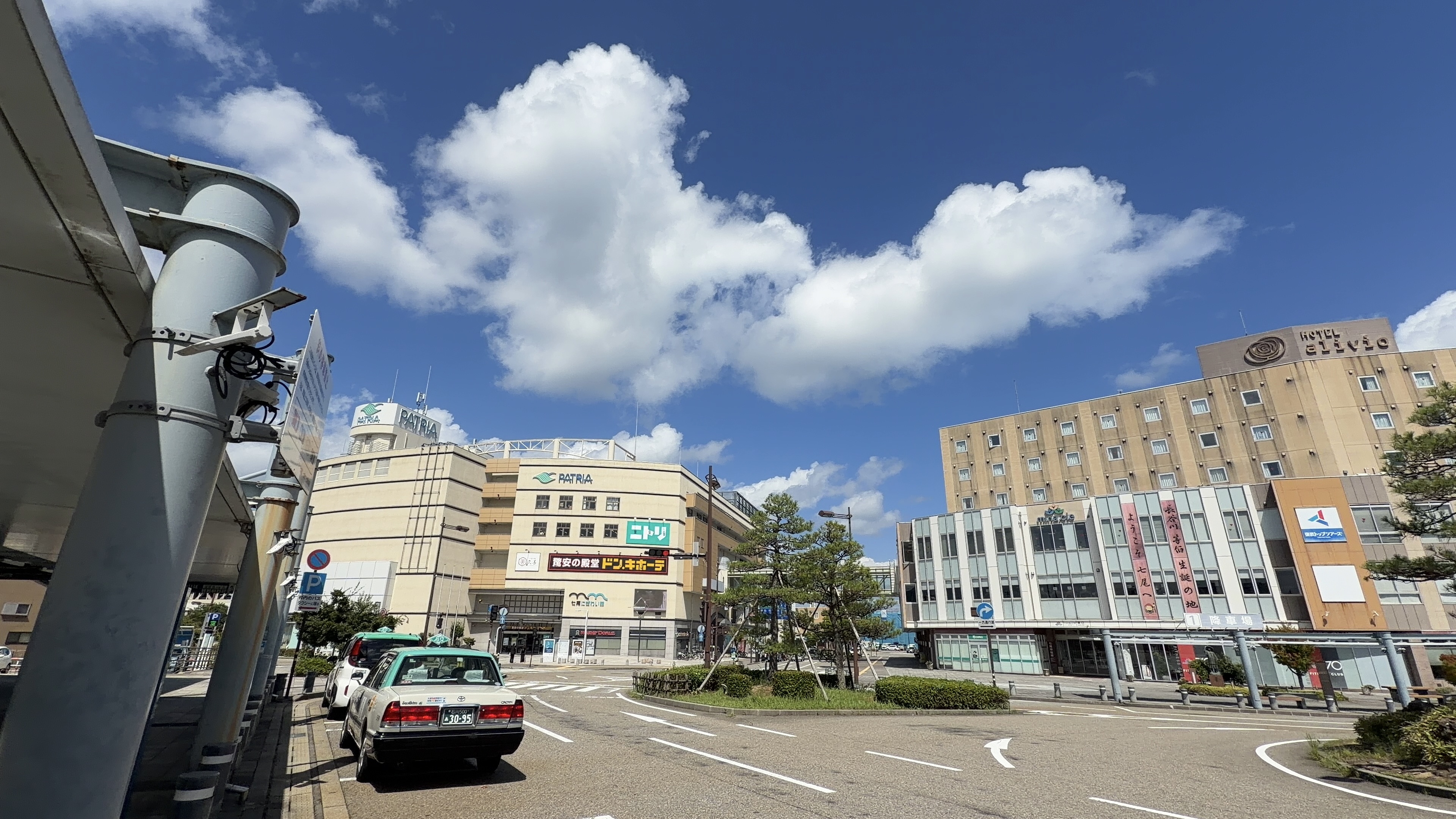 商業施設「PATRIA」の建物、ニトリとドン・キホーテの看板、手前にタクシーが並ぶロータリー
