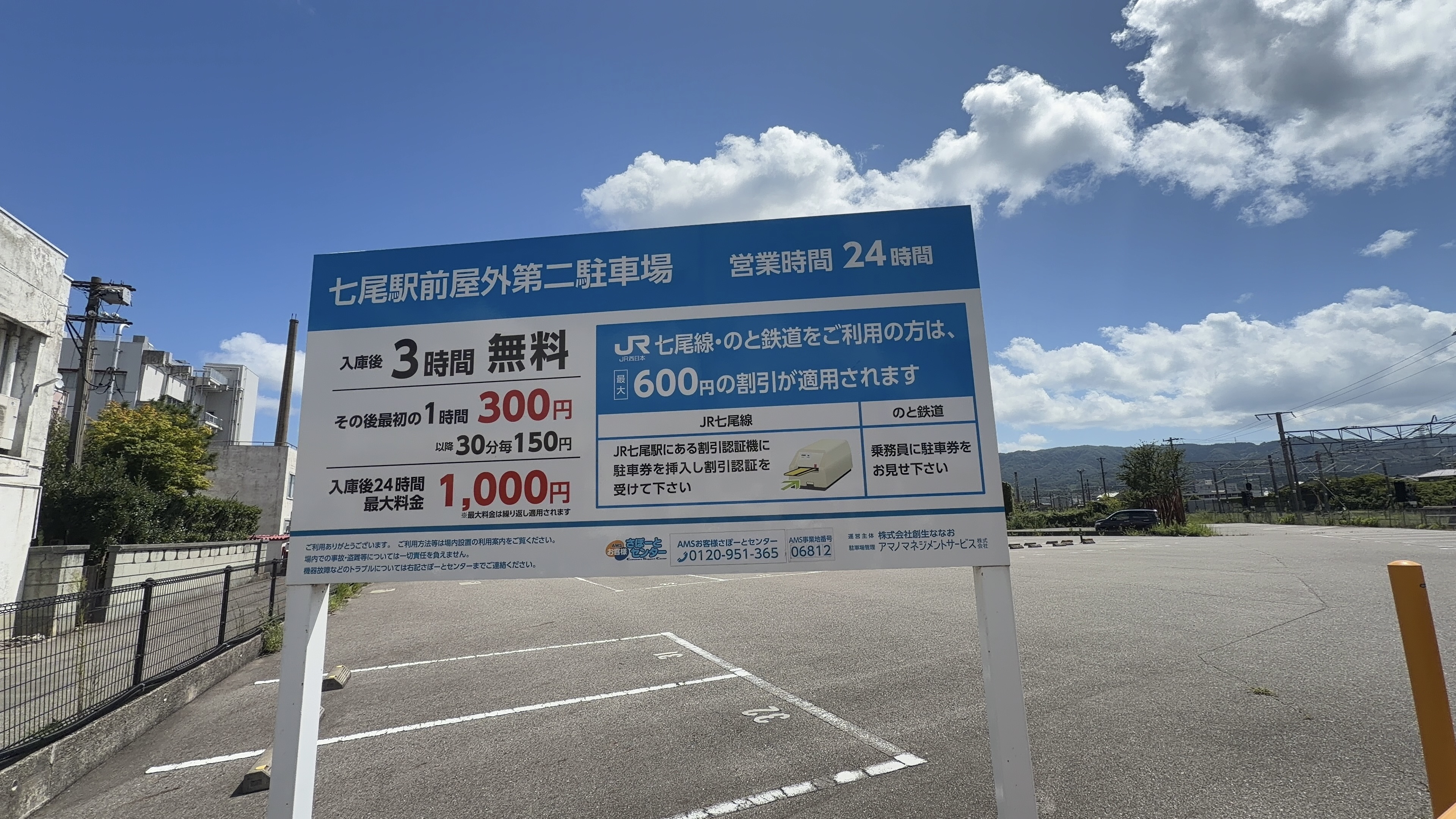 「七尾駅前屋外第二駐車場」の案内看板、営業時間24時間、JR・のと鉄道利用で最大600円割引の案内