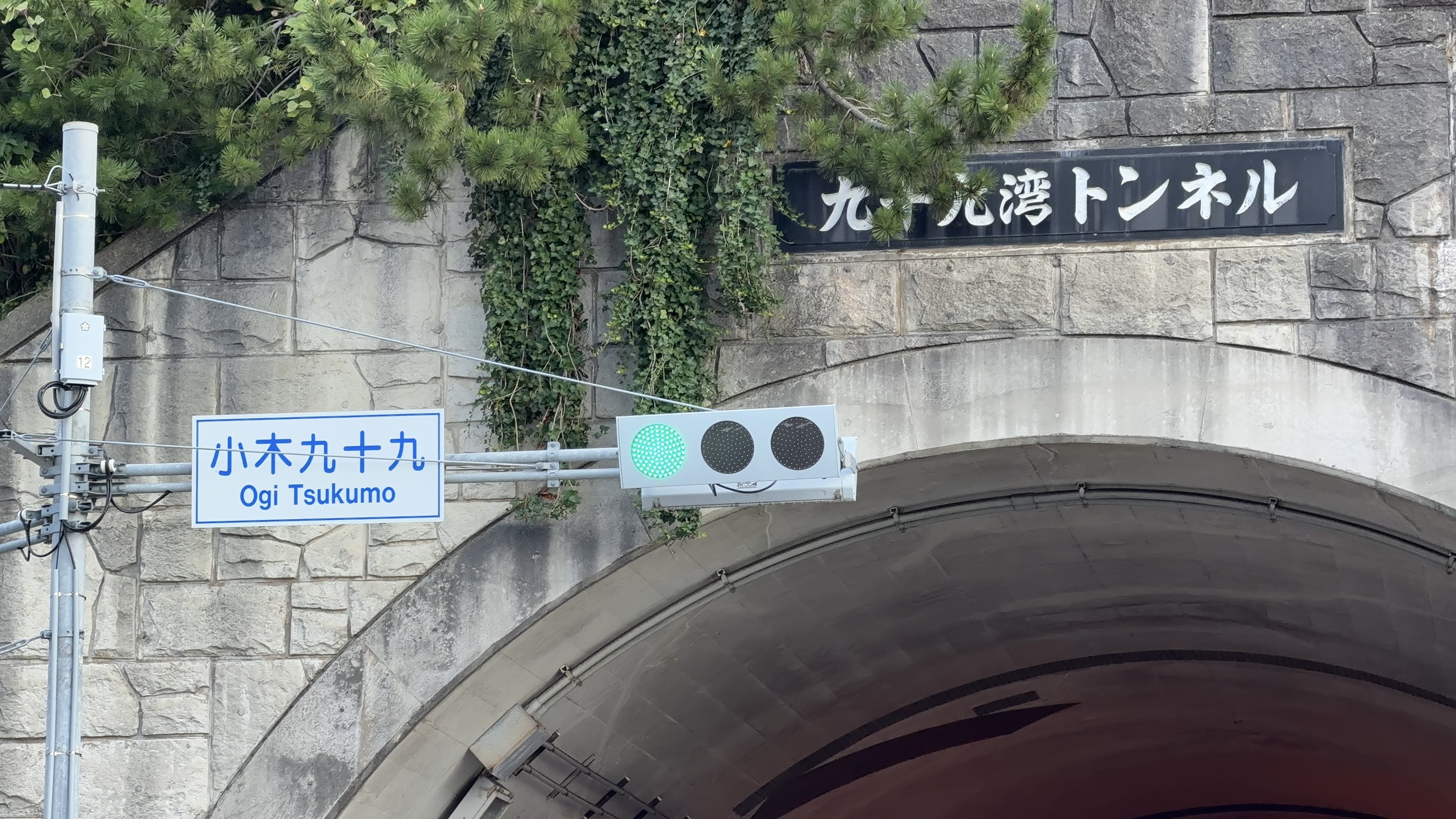 トンネル入口の看板「小木九十九 Ogi Tsukumo」のクローズアップ