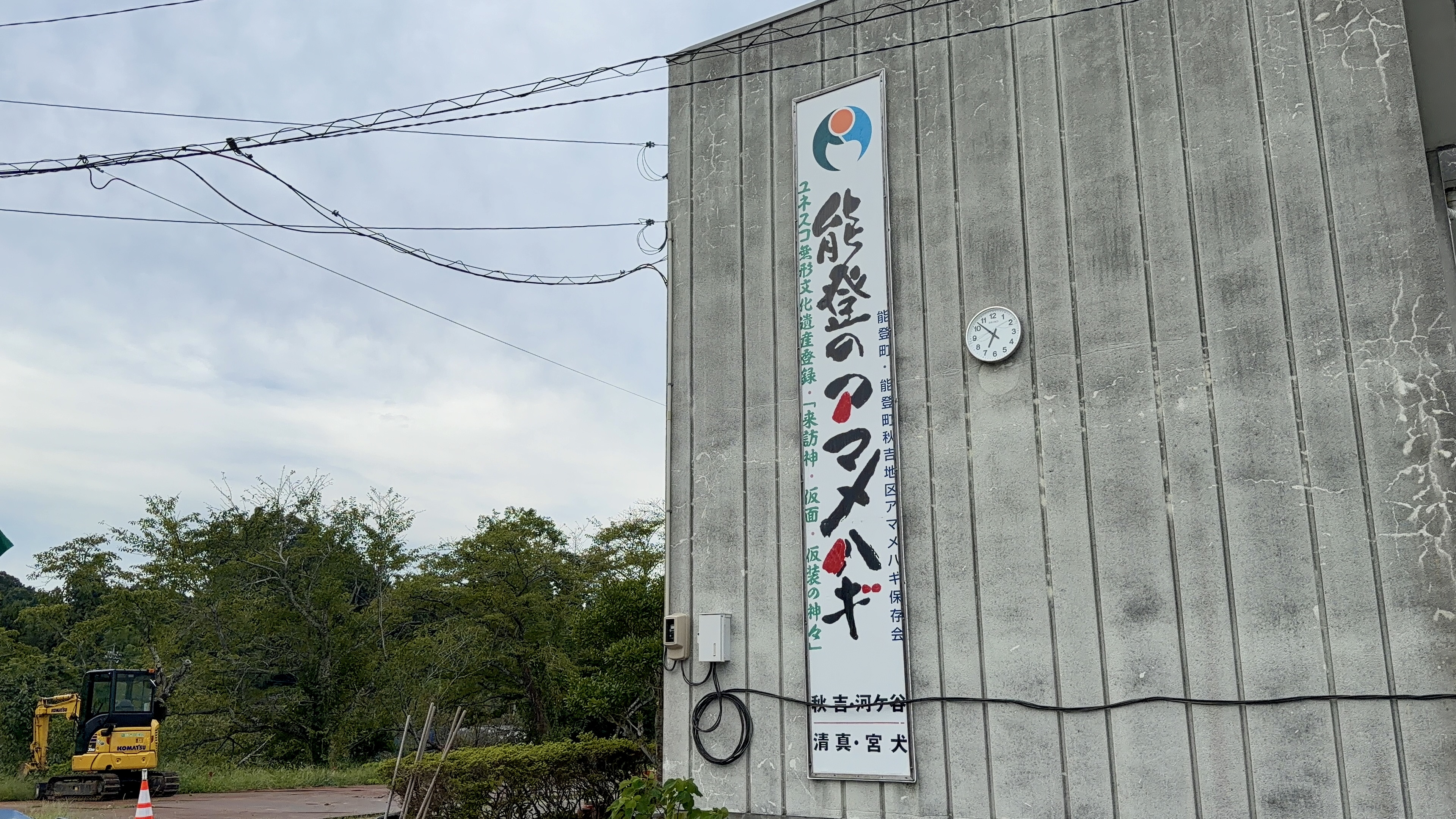 建物の壁に掲げられた「能登のアマメハギ」の大きな看板、ユネスコ無形文化遺産登録の文字