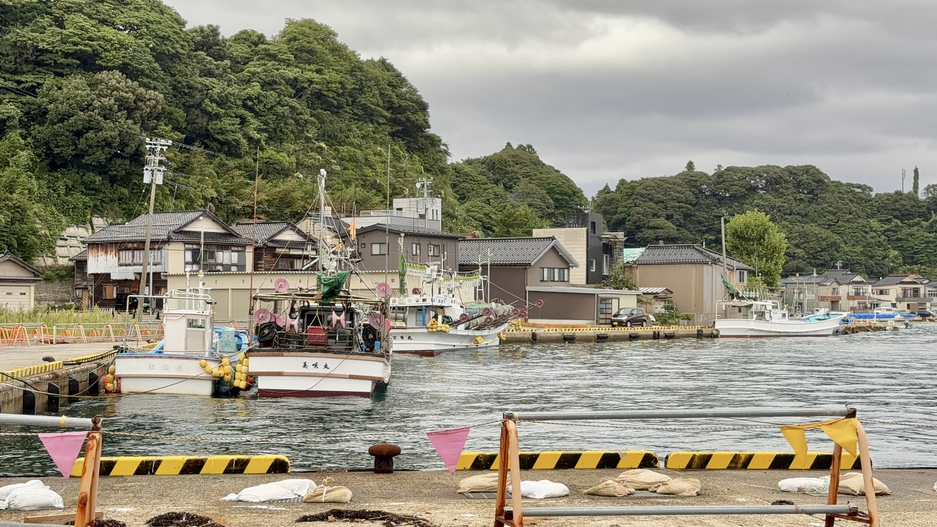 小木港に係留された漁船と、背後の山並み