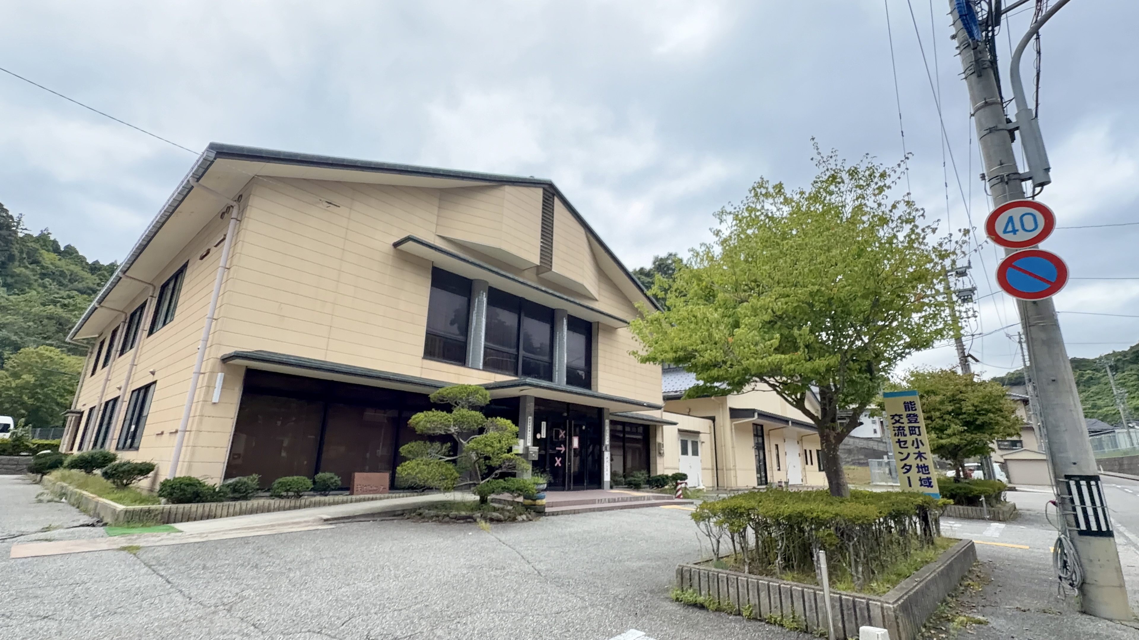 「能登町小木地域交流センター」の看板が立つ、クリーム色の建物