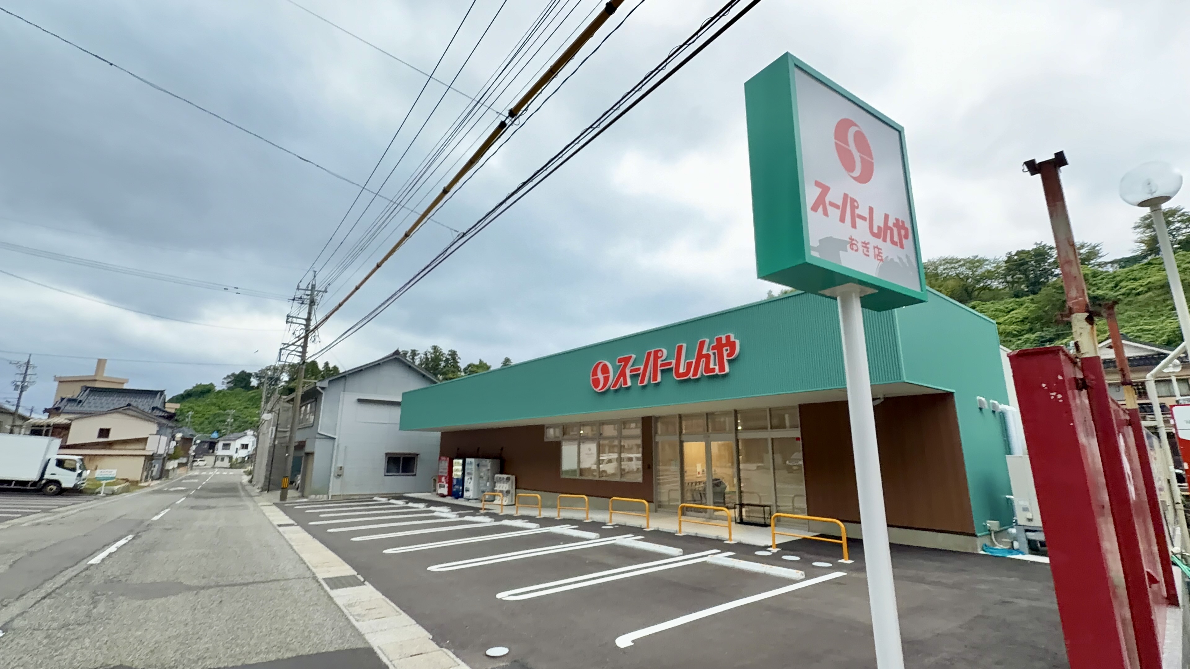 緑色の看板が目印の「スーパーしんや おき店」、広い駐車場を構えた新しい店舗